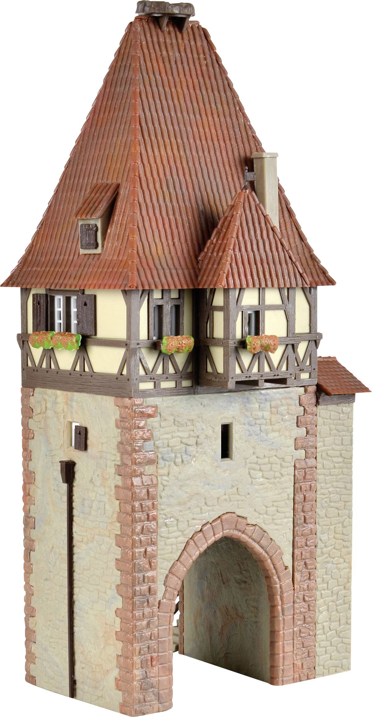 Model historické strážní věže s hrázděnou konstruktí a červenými taškami. Ozdobený květinami u oken, simulující středověkou architekturu.