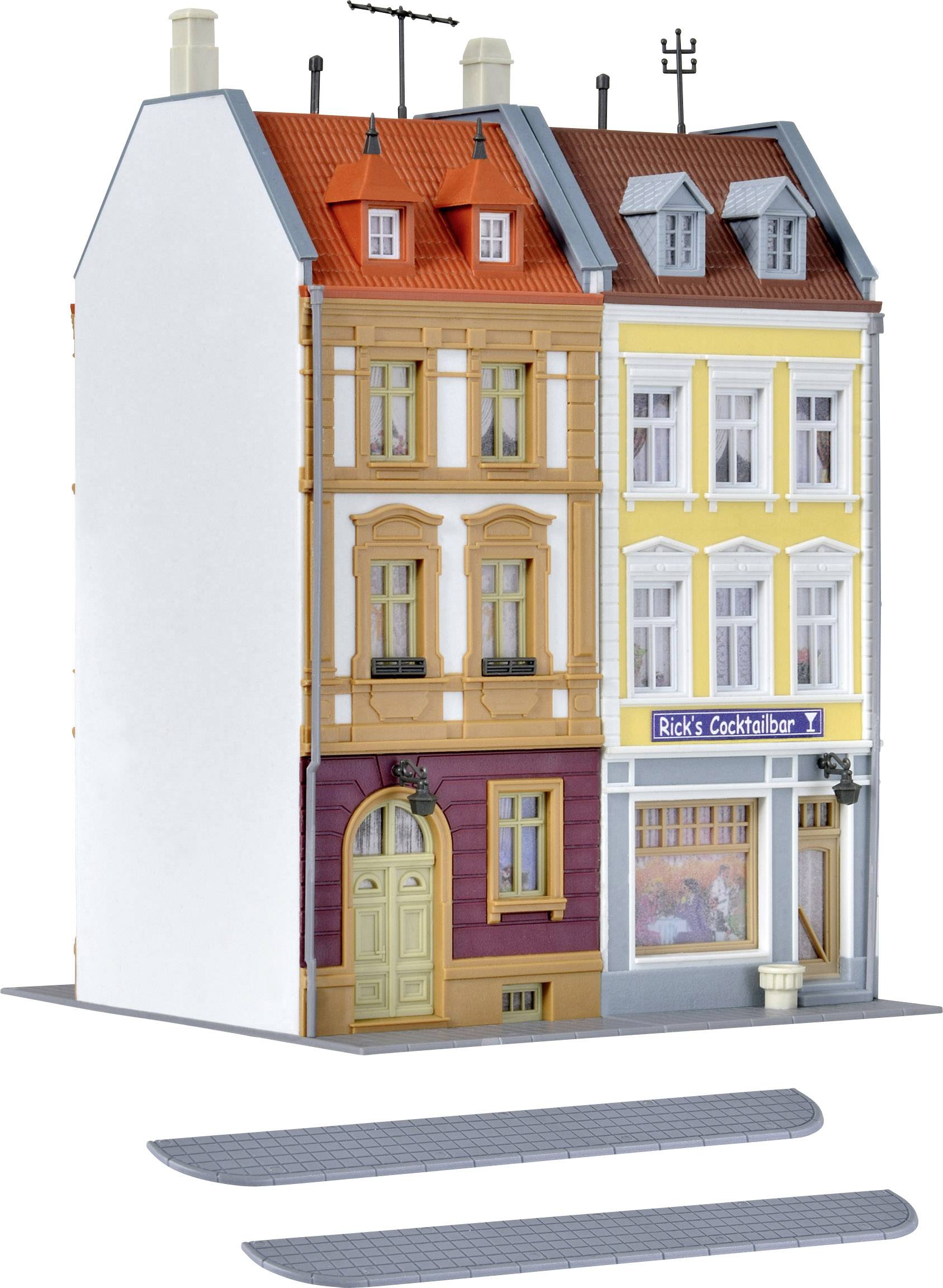 Model domu se třemi patry v pestrých barvách. Vlevo střecha v oranžovo-červené barvě, vpravo žlutá budova s 'Rick's Cocktailbar' v přízemí.
