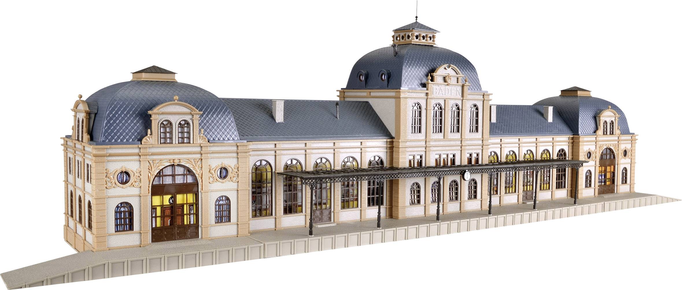 Model historické nádražní budovy s modrými kopulovitými střechami a precizně zdobeným průčelím, který stojí na stole.