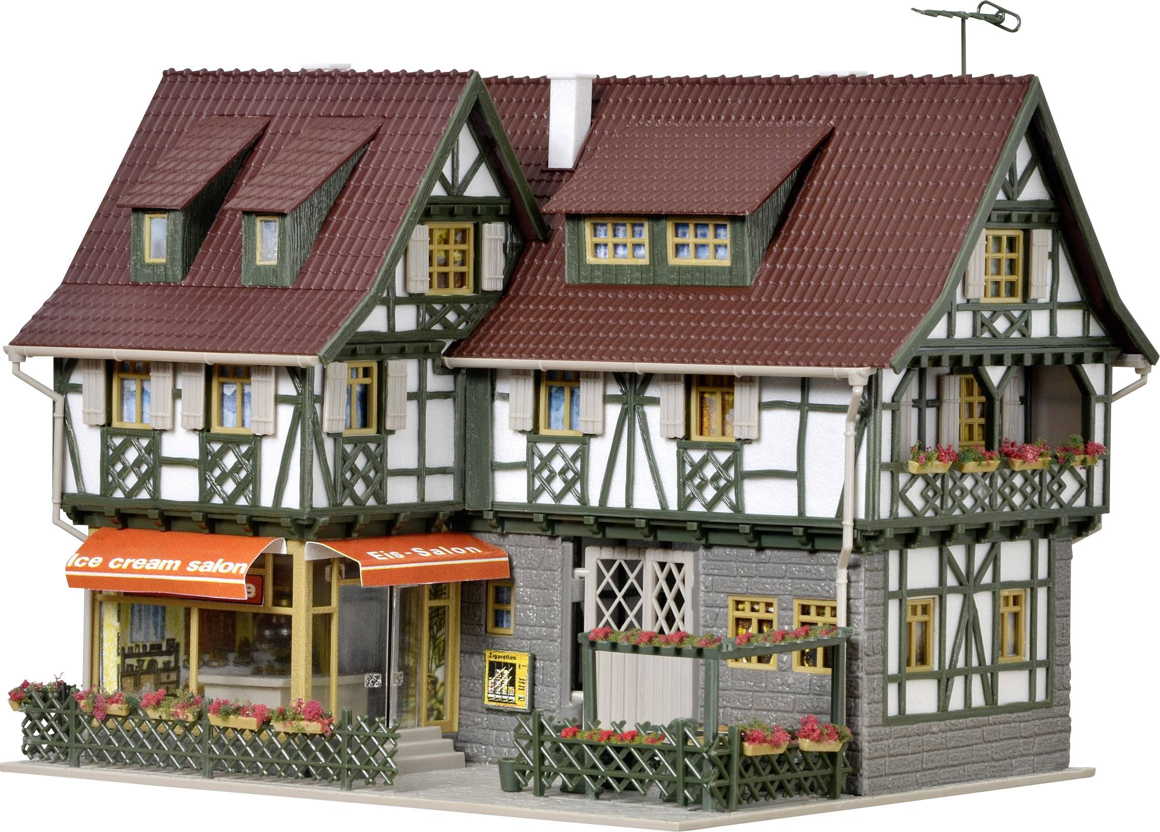 Miniaturní modelový dům ve stylu klasického hrázděného domu s červenými střechami a balkóny. Malá cedule s nápisem 'ice cream salon' visí nad vchodem.
