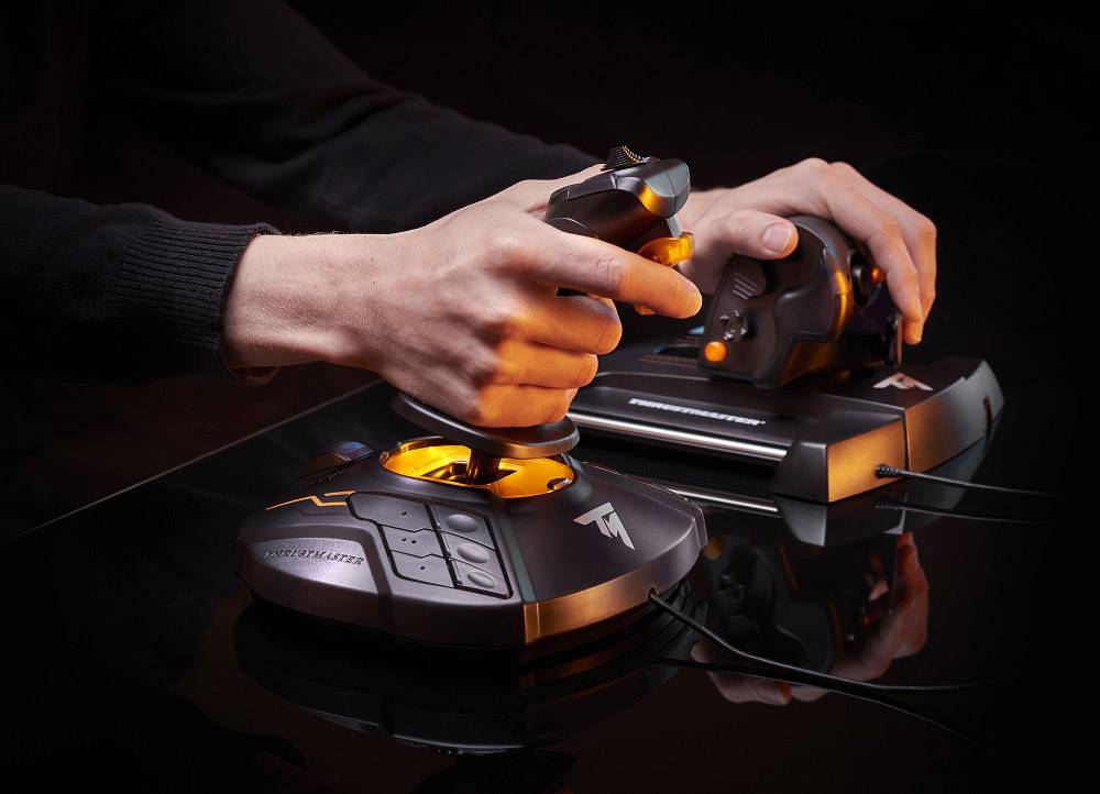 Osoba drží joystick a plynový ovladač, odražený na černém povrchu, určený pro letové nebo vesmírné simulace.