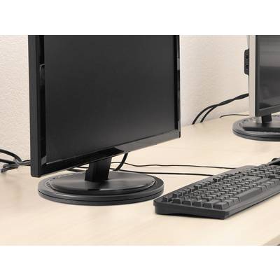 Počítačový monitor a klávesnice stojí na psacím stole v kanceláři. Kabely vedou za monitorem.