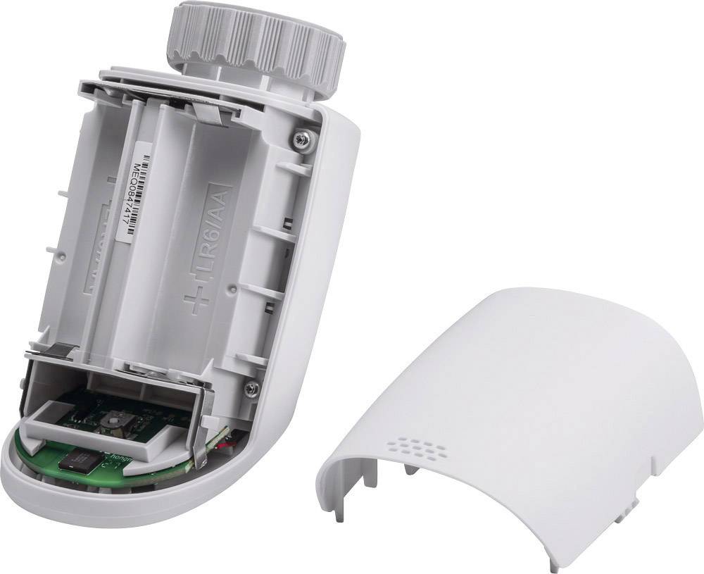 Bateriový termostat topného tělesa, částečně otevřený. Zobrazuje prostor pro baterii a elektronické komponenty.