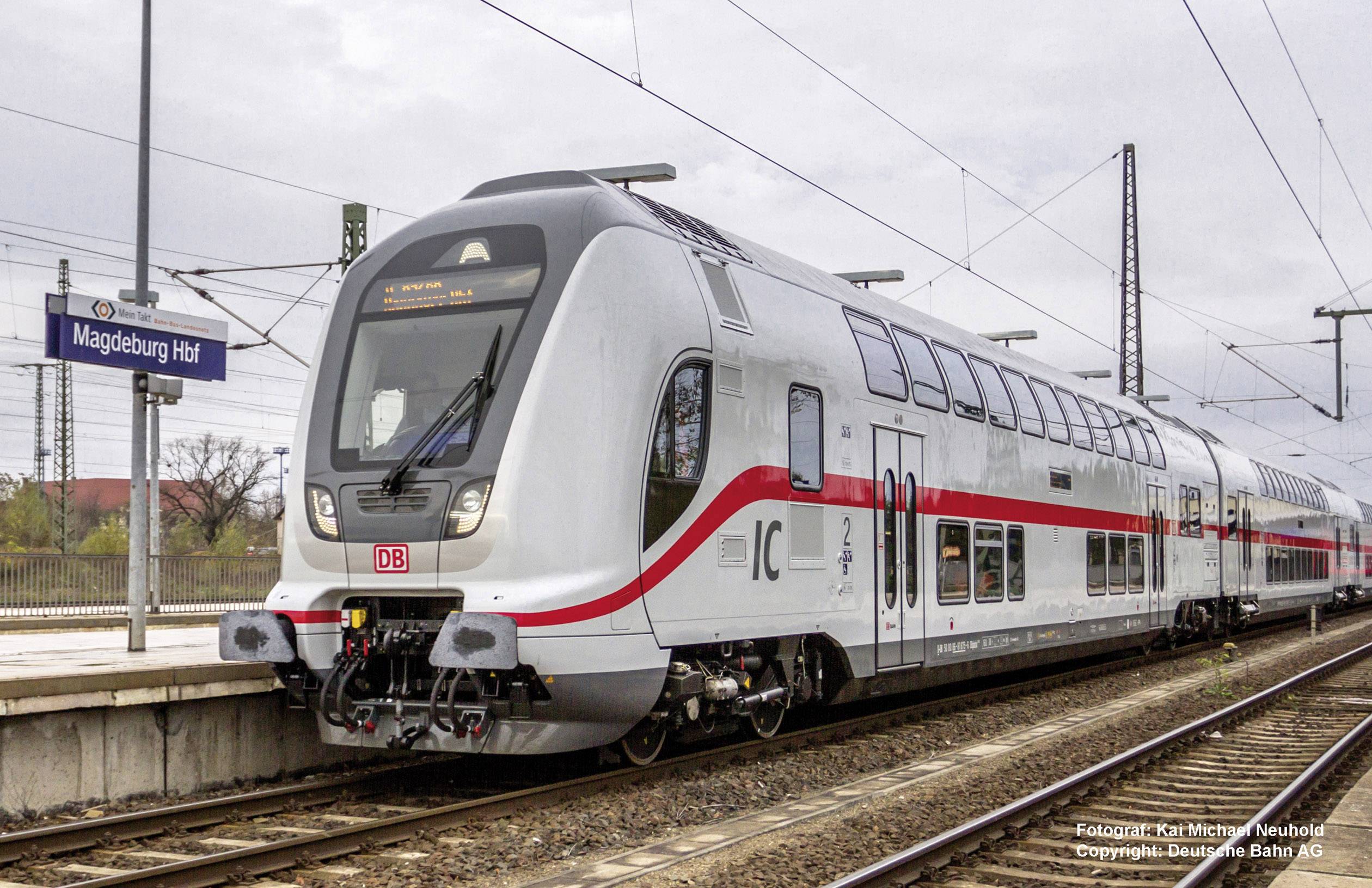 Moderní stříbrný dvoupatrový meziměstský vlak Deutsche Bahn stojí na nádraží v Magdeburgu připravený k odjezdu.