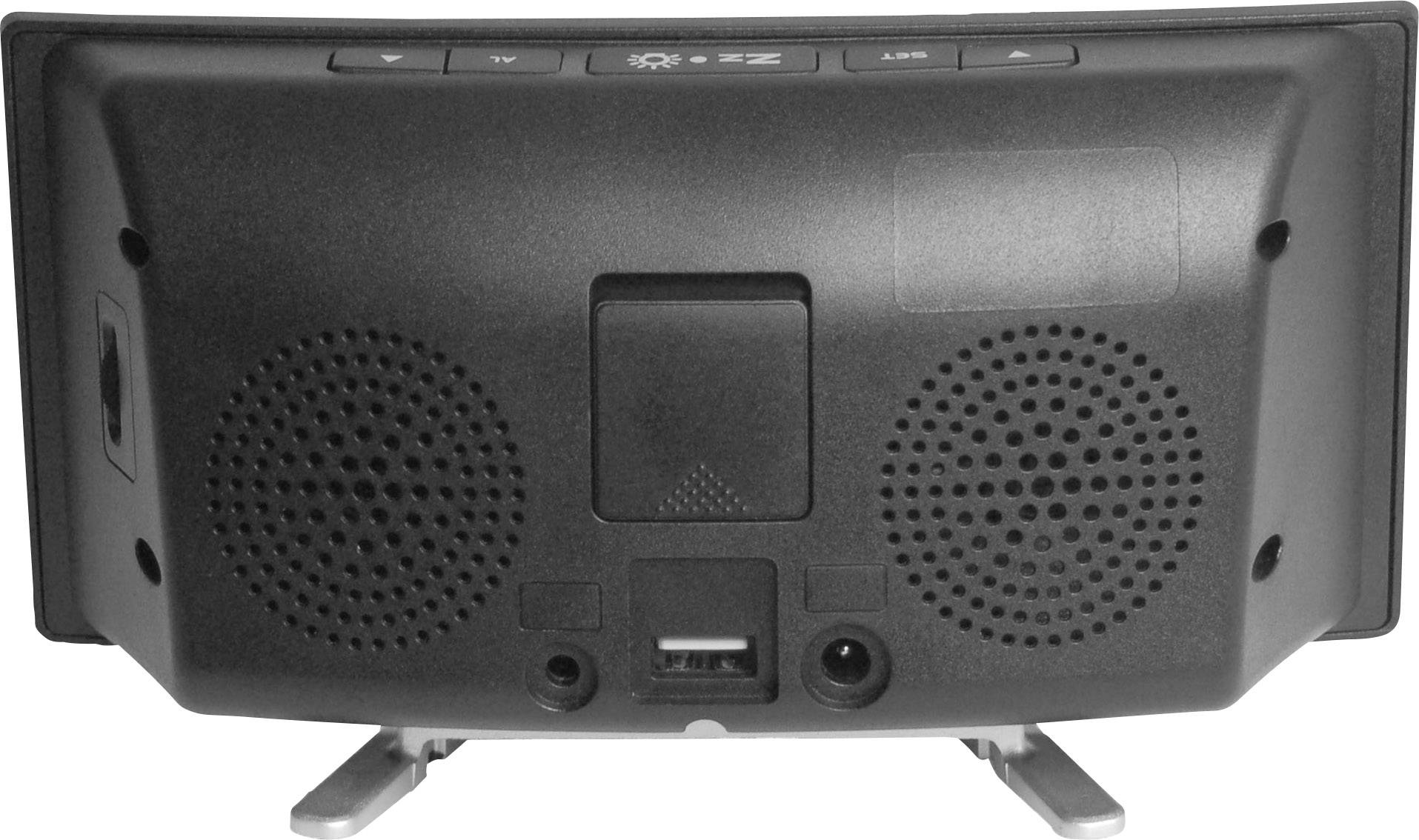 Zadní strana elektronického zařízení s reproduktory, USB portem a tlačítky. Zařízení stojí na sklopných stojanech.