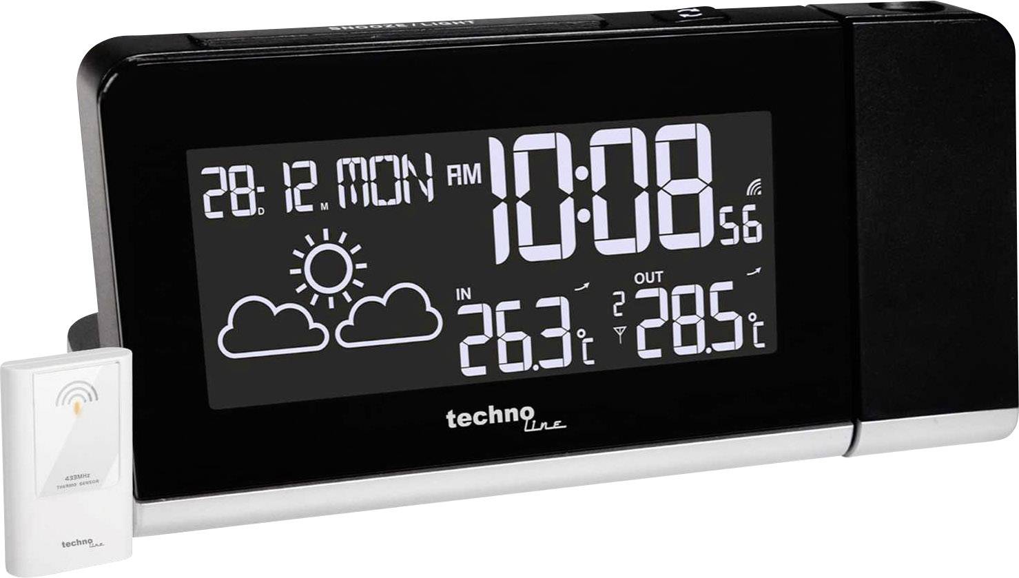 Černý digitální budík ukazuje datum '28.12. Pondělí', čas '10:08', počasí se sluncem a mraky, teplota uvnitř '26,3°C', venku '28,5°C'.