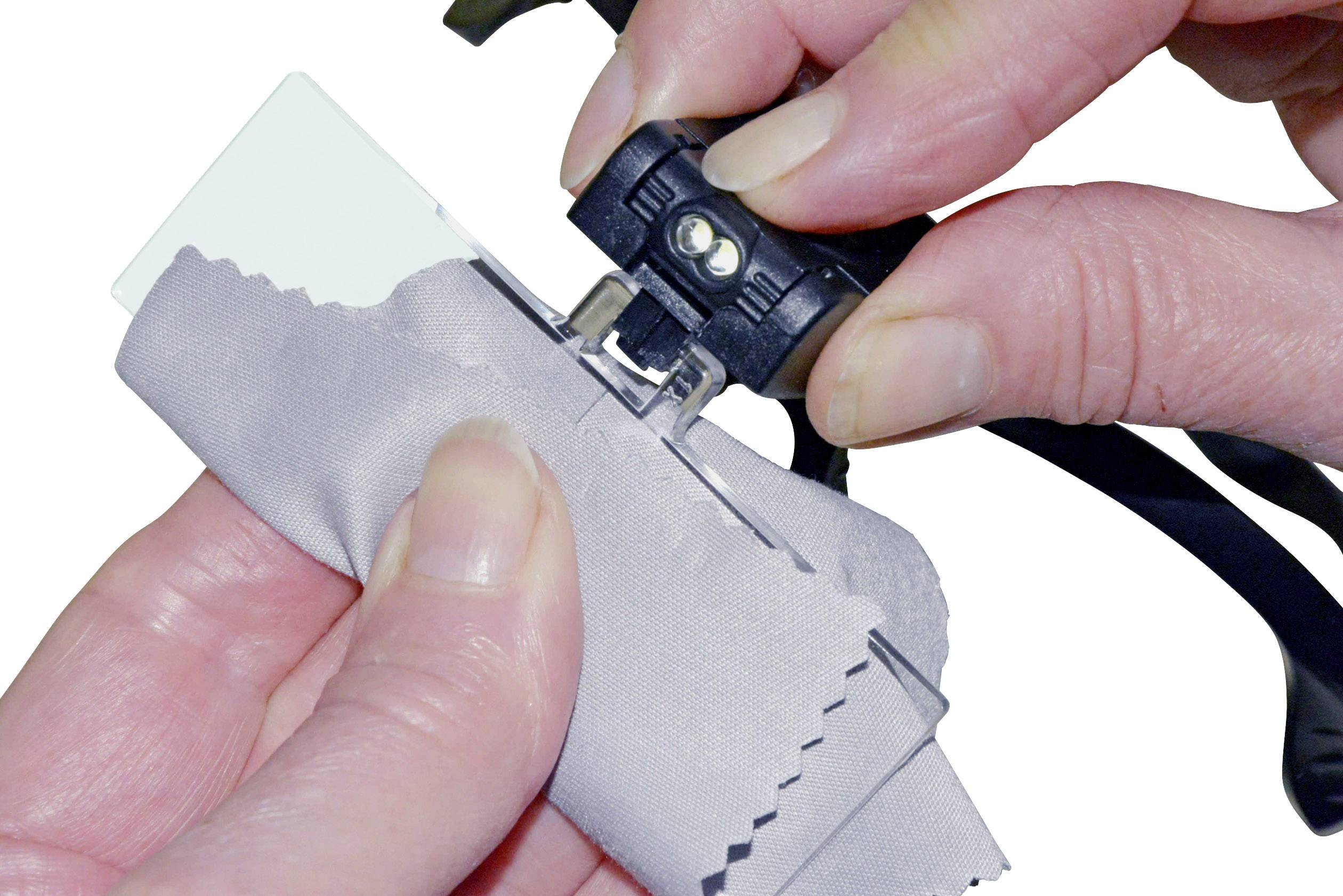 Jedna ruka drží čisticí utěrku a přístroj na čištění brýlí nad brýlemi.