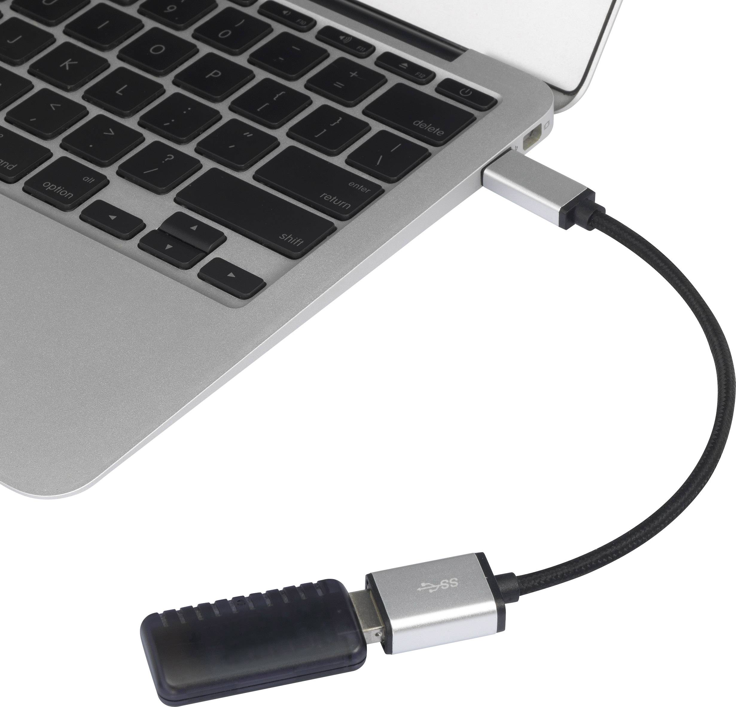 Notebook s černou klávesnicí je připojeno k USB flash disku pomocí krátkého kabelu.