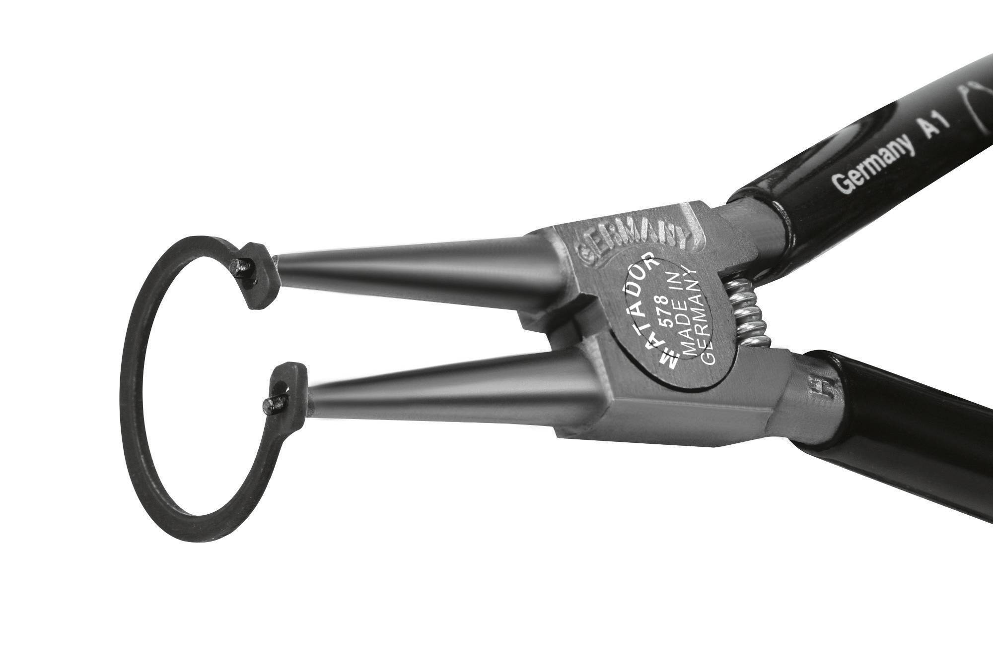 Nástroj, který drží malý kovový kroužek. Kleště mají jemný, přesný hrot, vhodný pro detailní práce.