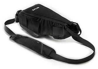 Černá crossbody taška s nastavitelným popruhem leží plochá na povrchu. Má několik kapes.