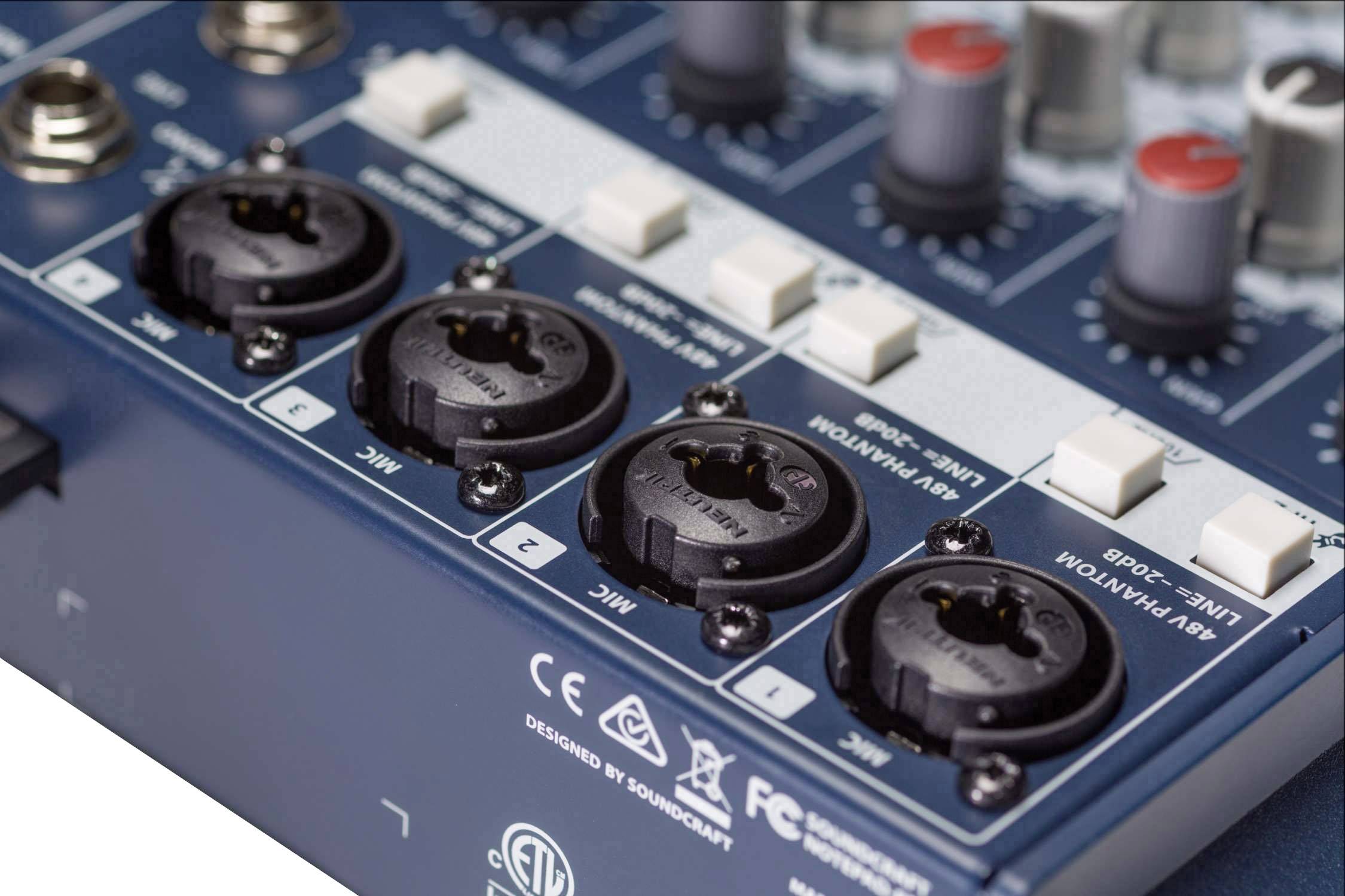 Mixážní pult s čtyřmi XLR vstupy a několika otočnými ovladači, tlačítky a logy technických specifikací na povrchu.