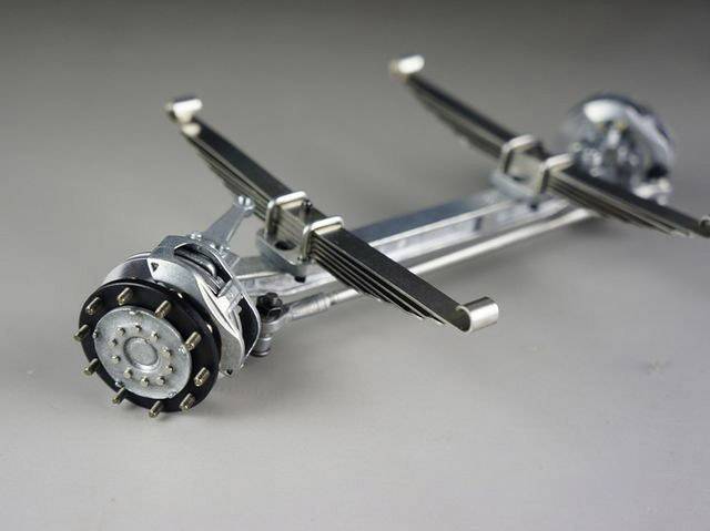 Zobrazení mechanického modelu se dvěma souběžně uspořádanými rotačními osami a pružinami, pravděpodobně součást podvozku.