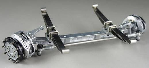 Náprava s listovými pružinami a brzdami na šedém pozadí, zobrazuje mechanické komponenty vozidla pro technickou analýzu.