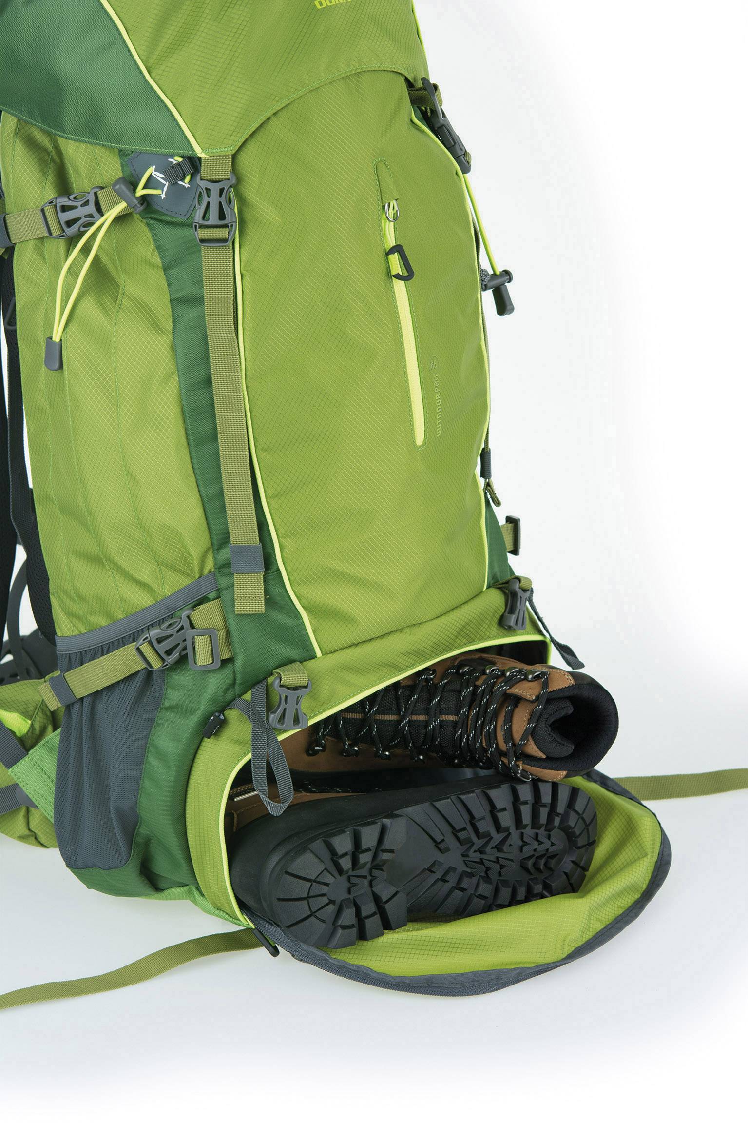 Zelený turistický batoh s postranní kapsou, ve které je uložen pár černých pohorků. Batoh má několik popruhů a kapes.