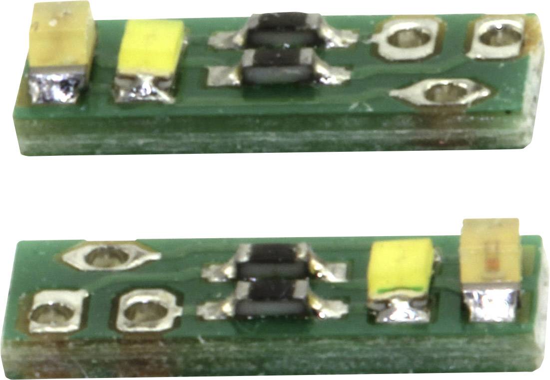 Dvě malé elektronické součástky na zelené desce plošných spojů. Každá obsahuje dva žluté obdélníky a kovové kontaktní body.