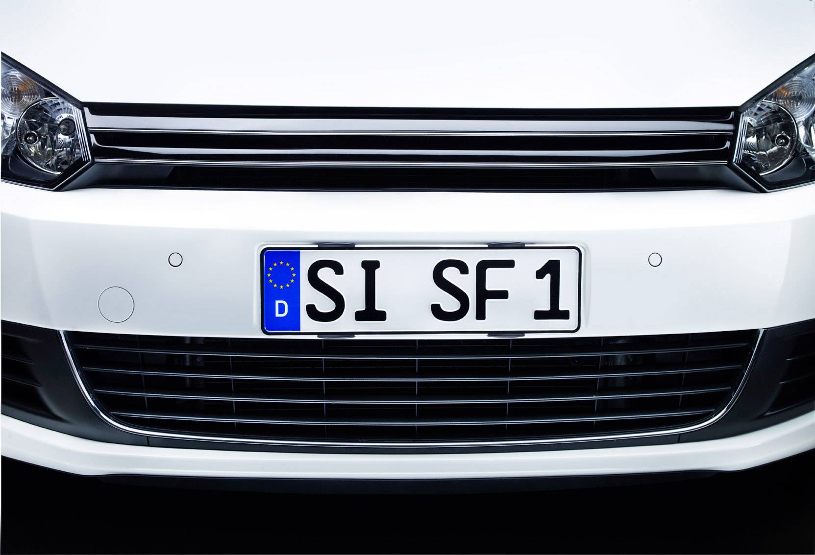 Detailní pohled na bílé auto s německou registrační značkou 'SI SF1'.