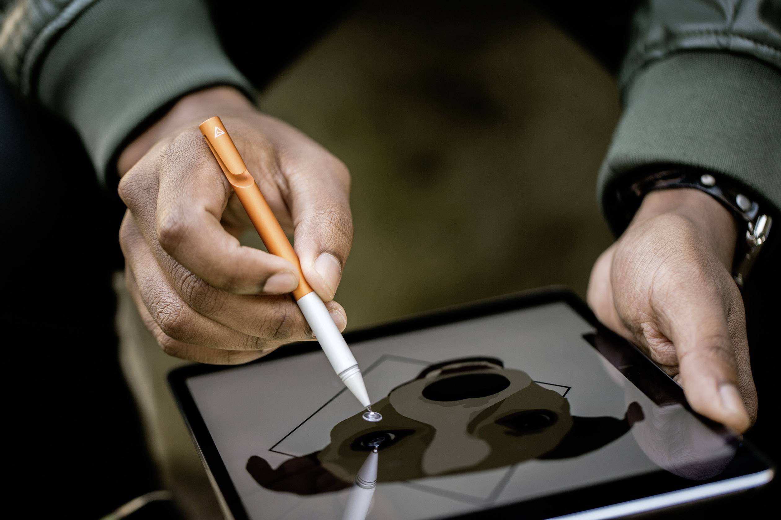 Osoba kreslí geometrickou ilustraci zvířete perem na tabletu. Zaměření na ruce a techniku.