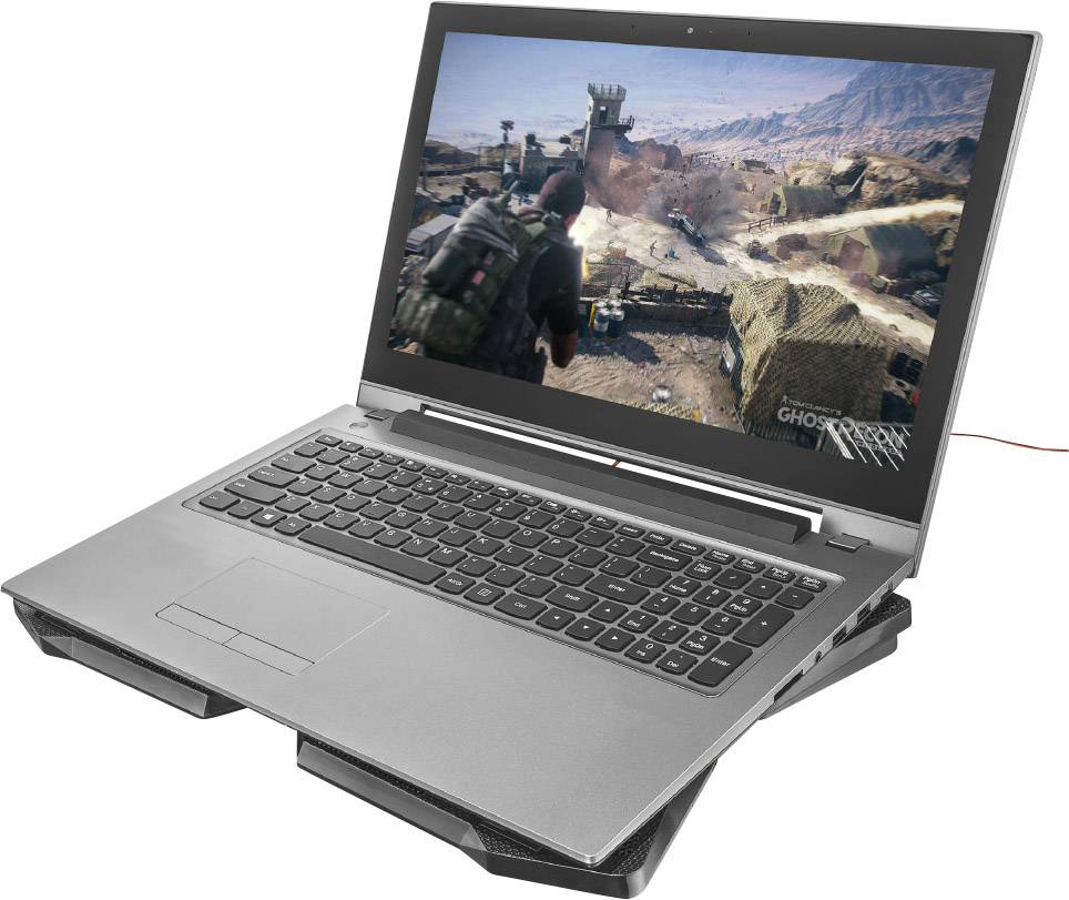 Laptop zobrazuje videoherní scénu s vojenskou krajinou na obrazovce. Postava se pohybuje pouštním prostředím.