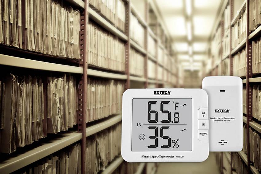 Digitální teploměr a vlhkoměr ukazují 65,8 stupňů Fahrenheita a 35 % relativní vlhkosti, umístěné v archivu dokumentů.