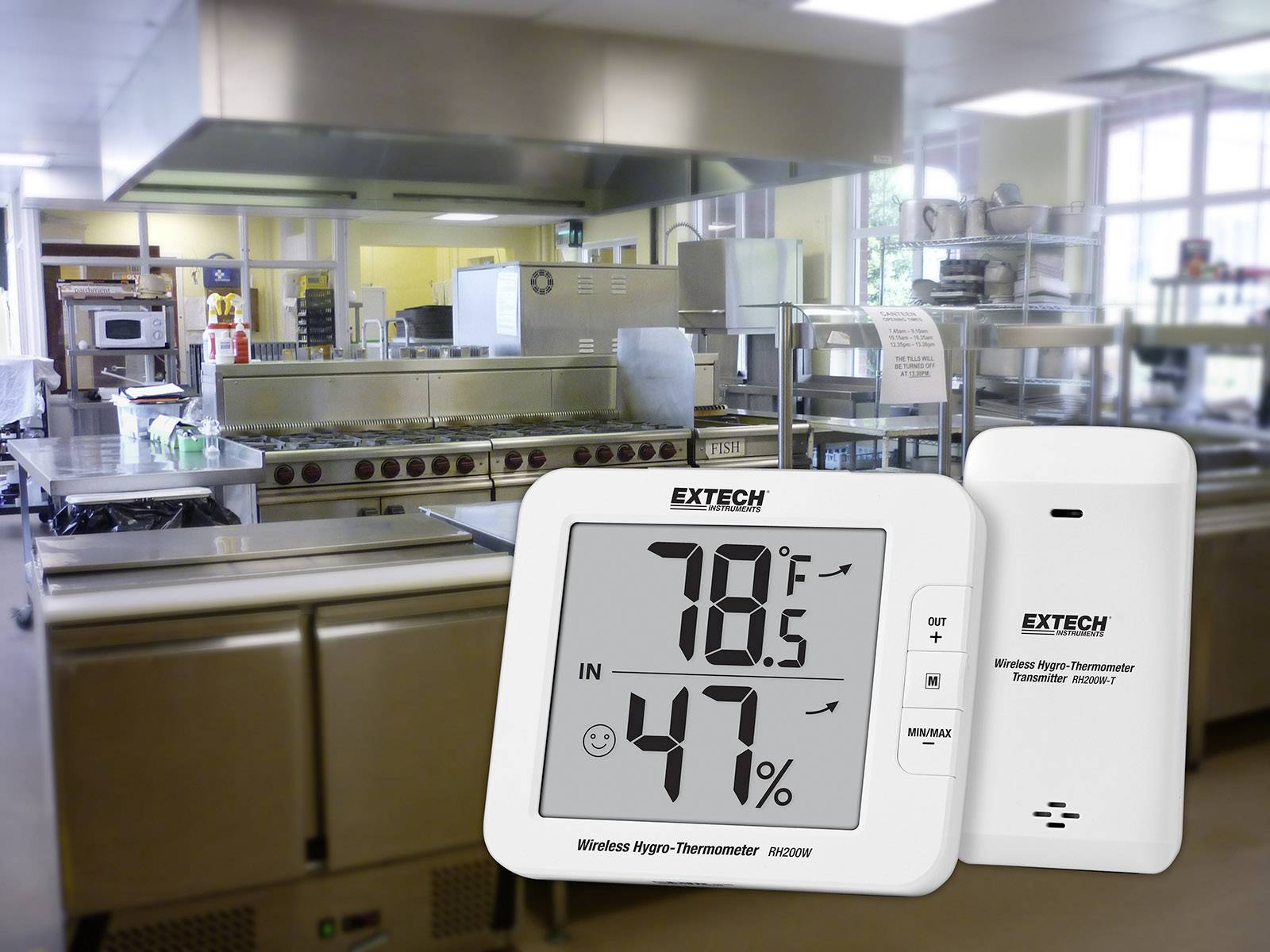 Digitální teploměr zobrazující '78,5 °F' a '47 %' před moderní velkokapacitní kuchyní, což poukazuje na kontrolu teploty a vlhkosti.