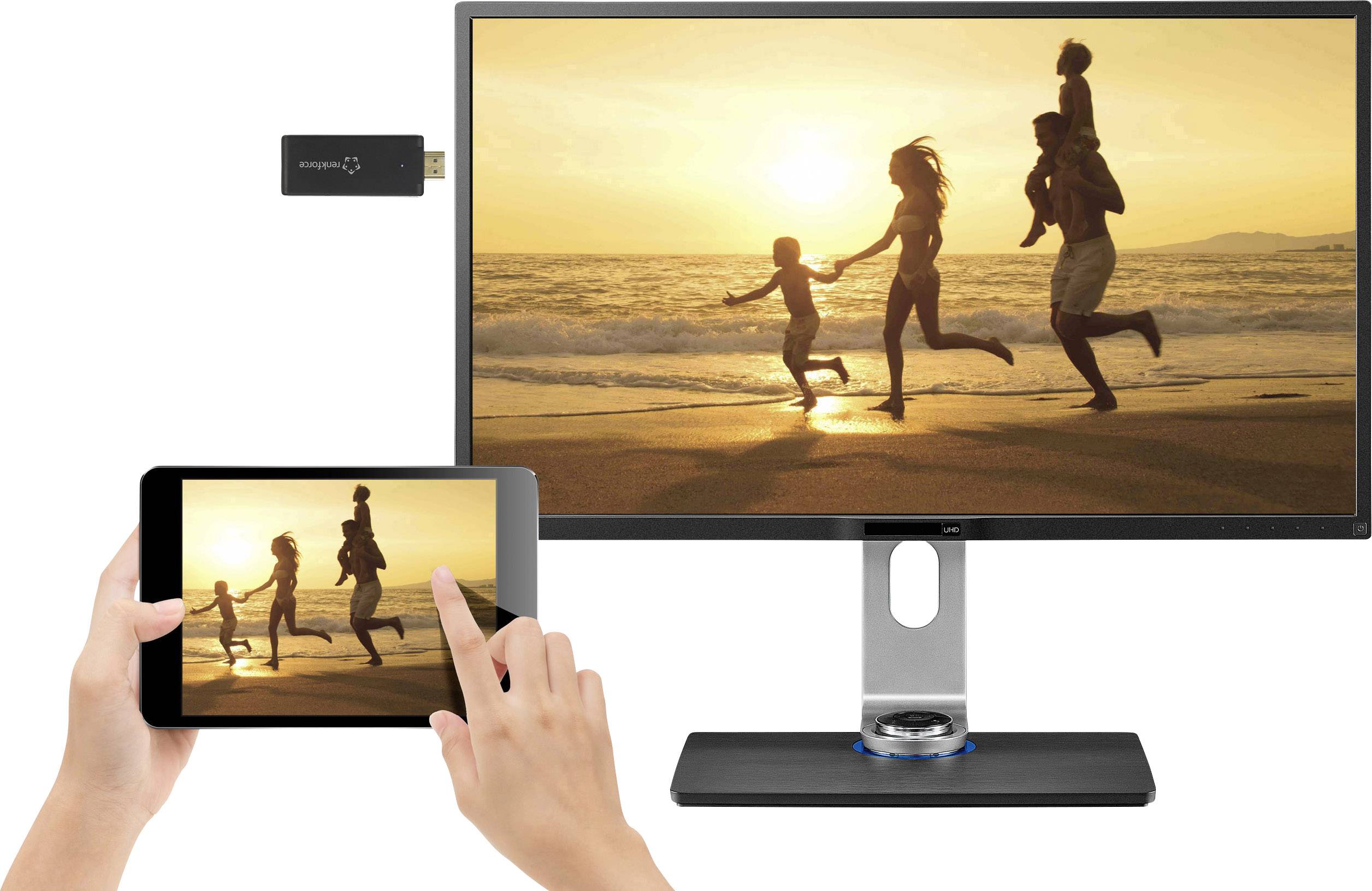 Jedna rodina vesele kráčí po pláži při západu slunce. Stejný obraz je streamován z tabletu na monitor.