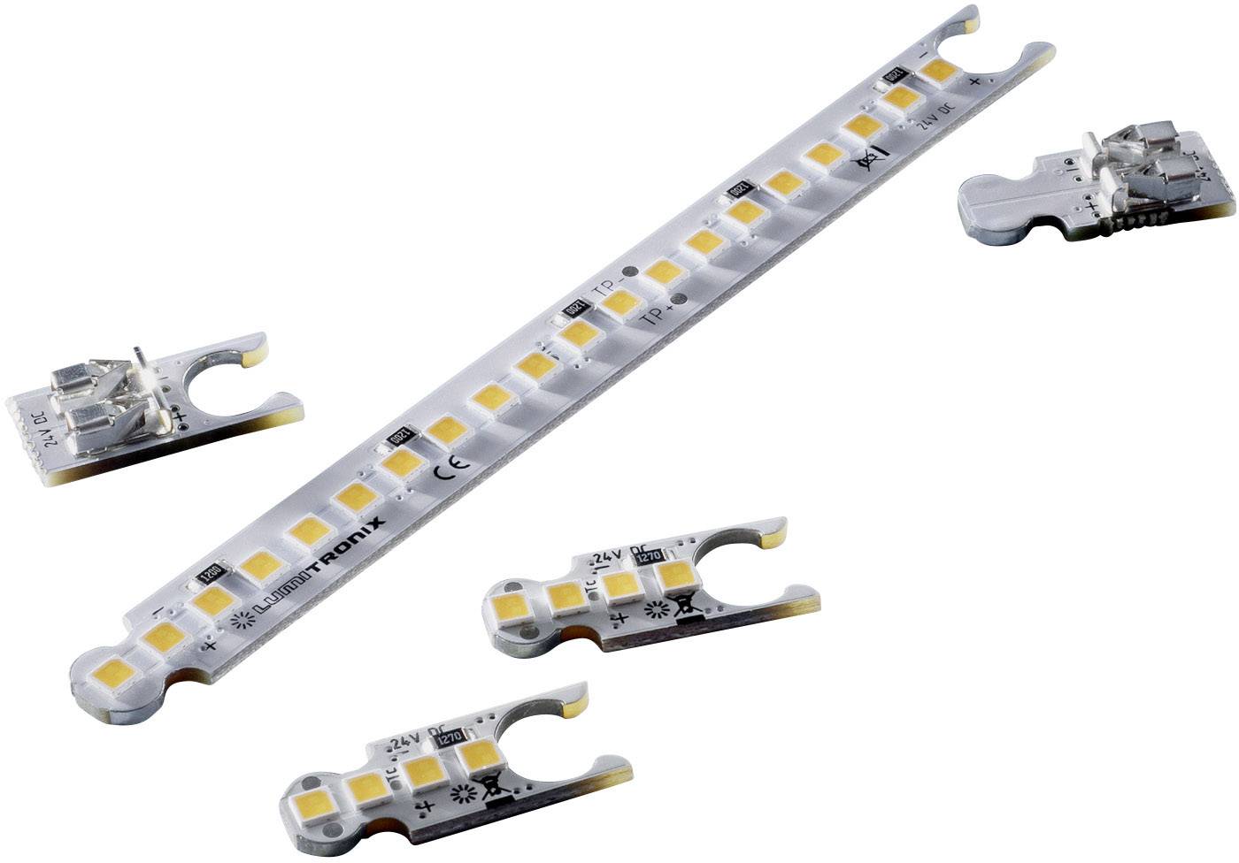 LED pásek a několik LED modulů leží na bílém pozadí. Pásek ukazuje žluté světelné prvky a technické symboly.