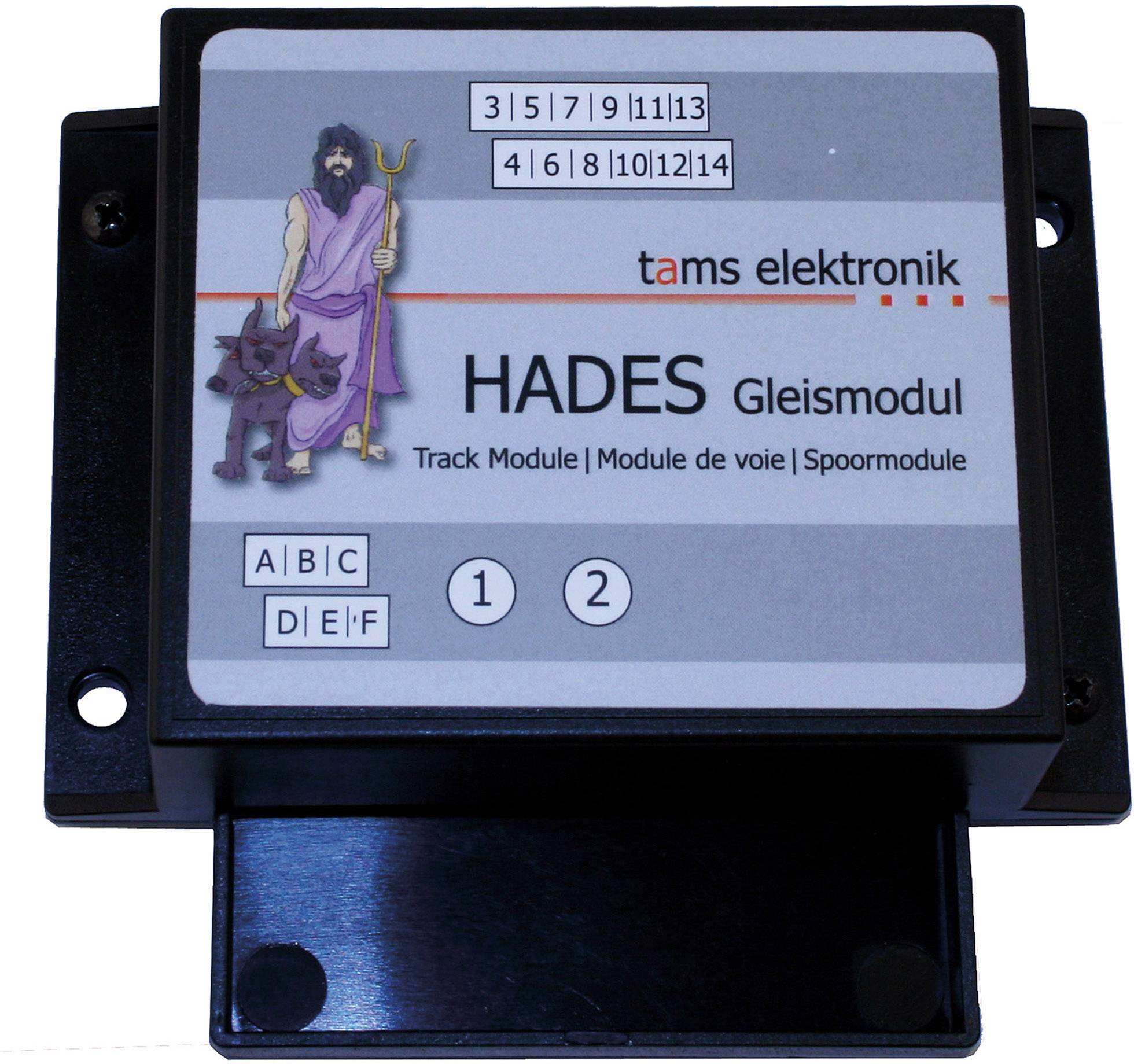Černý elektronický modul tratě Tams HADES s obrázkem postavy s holí a psem vedle něj.
