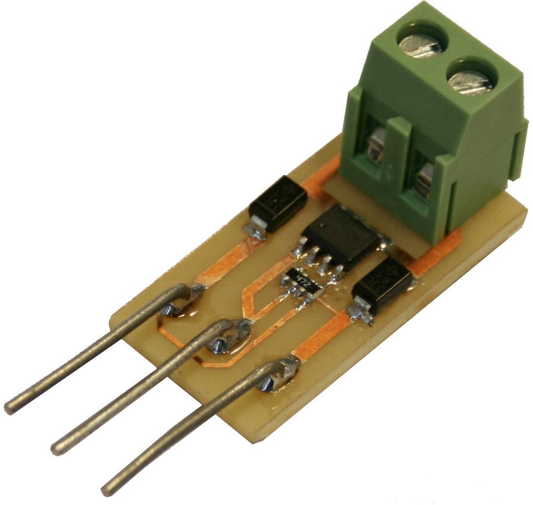 Elektronický modul se zeleným konektorem, třemi kolíky a několika černými prvky na malé desce plošných spojů.