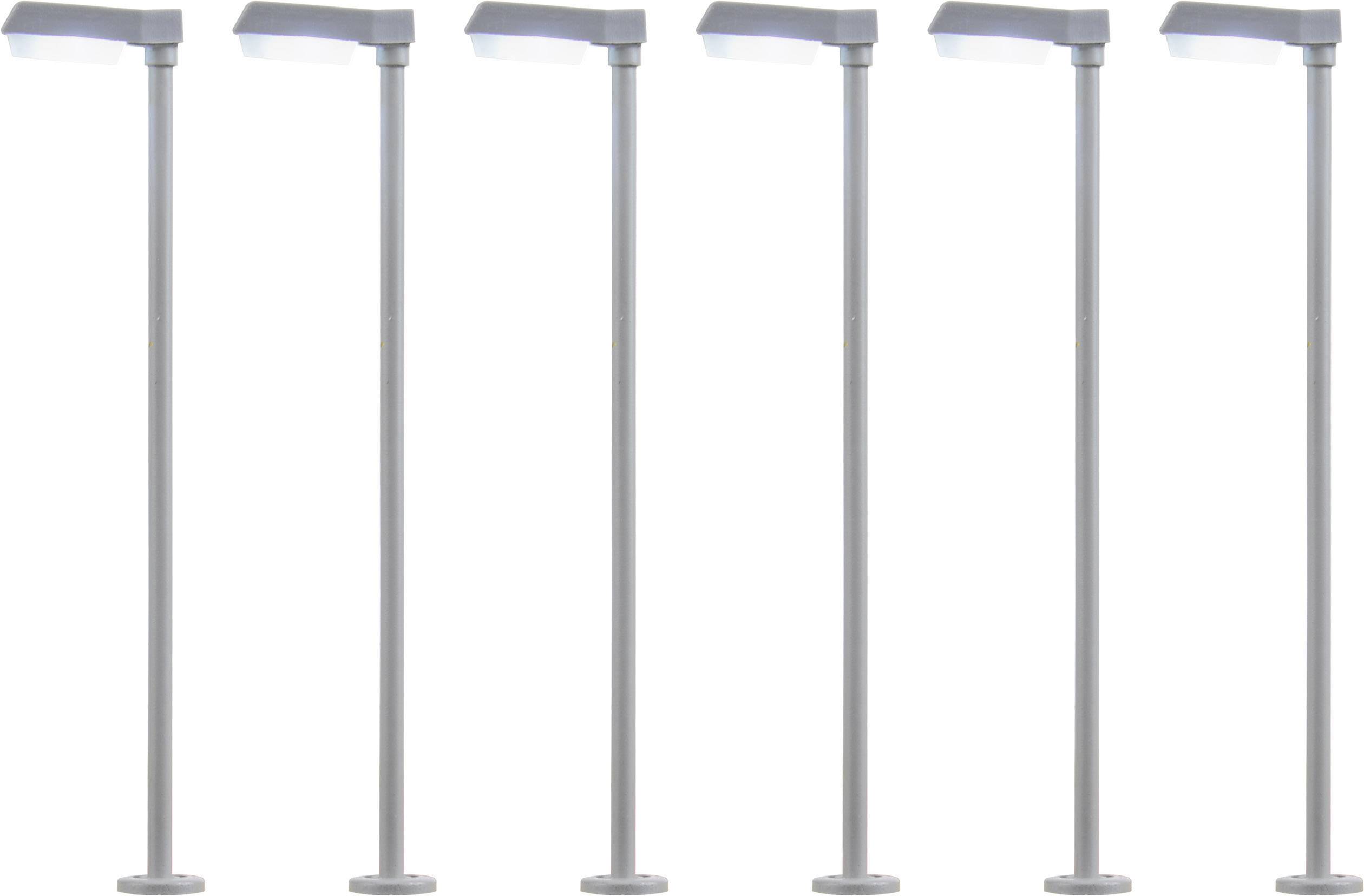 Šest identických moderních pouličních lamp v řadě, rovnoměrně rozmístěných na bílém pozadí.