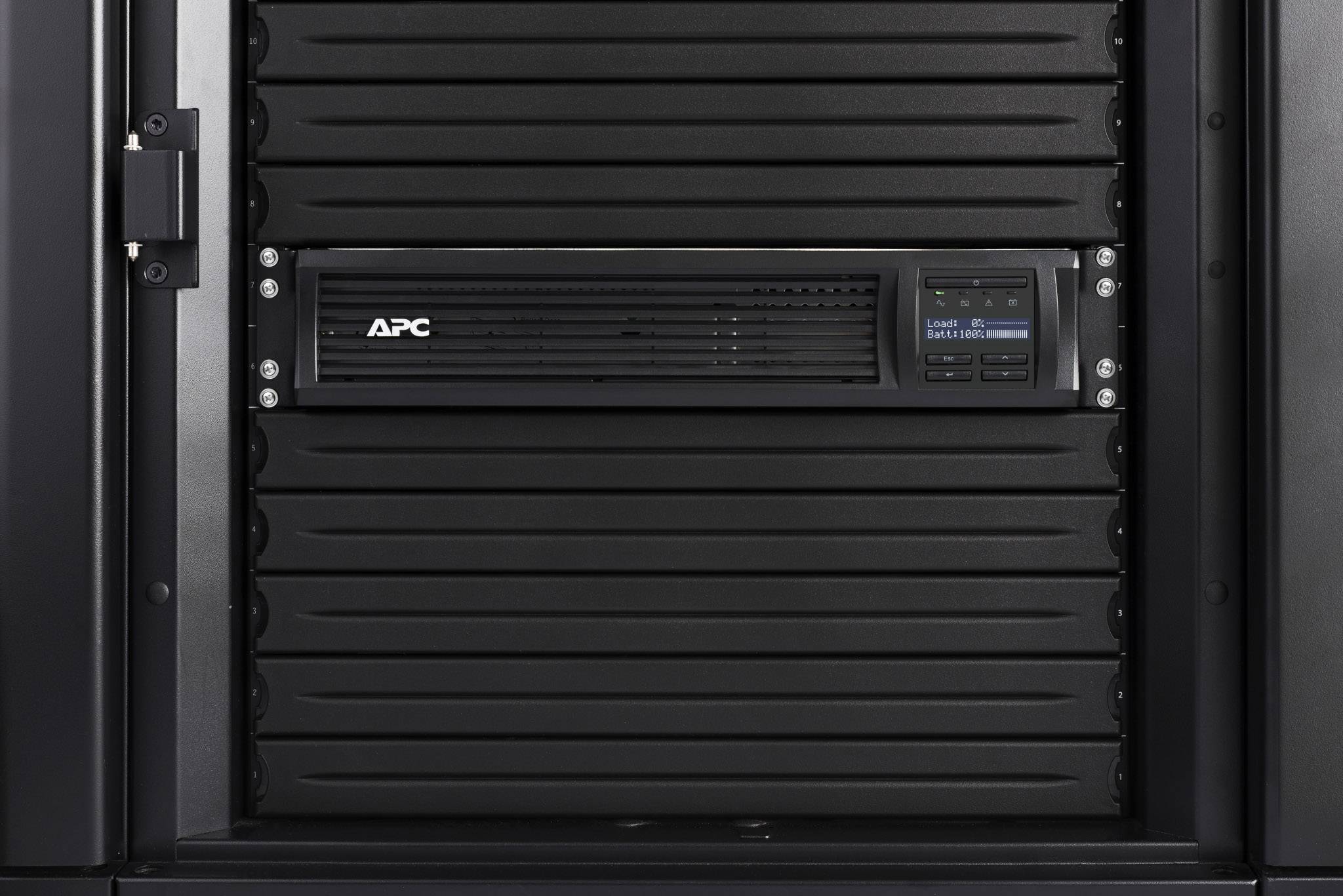 Černá serverová skříň s přístrojem APC uprostřed. Displej zařízení zobrazuje provozní informace.
