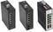Tři průmyslové síťové switche, každý s několika ethernetovými porty. Jeden ukazuje barevné porty a stavové indikátory, ostatní mají jednodušší design.