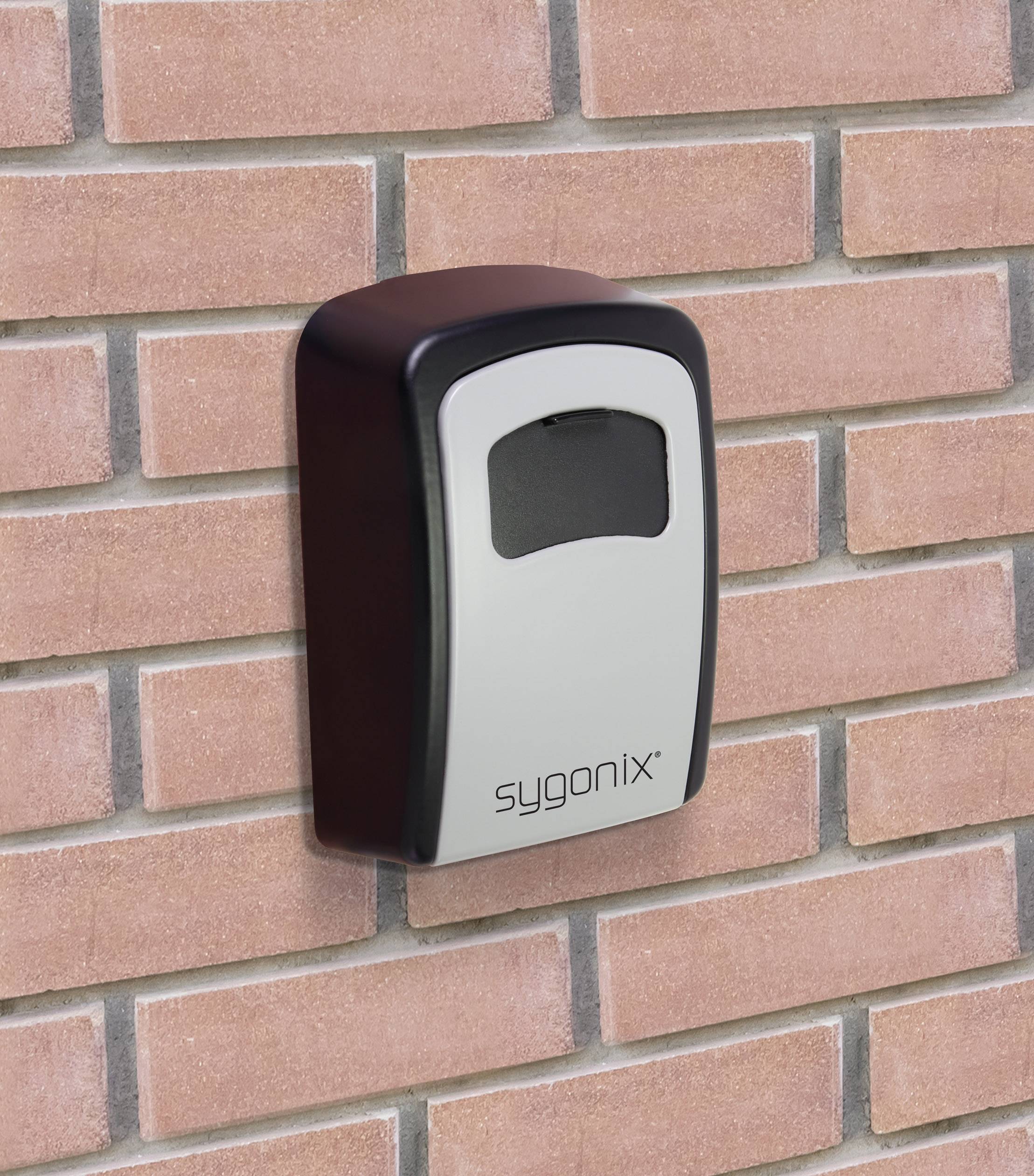 Zařízení pro kontrolu přístupu 'Sygonix' namontované na cihlové zdi. Zařízení má okénko pro rozpoznání přístupových karet.