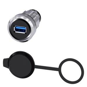 USB port s krytem. Port je obklopen kovovým pouzdrem, kryt je kulatý a černý.