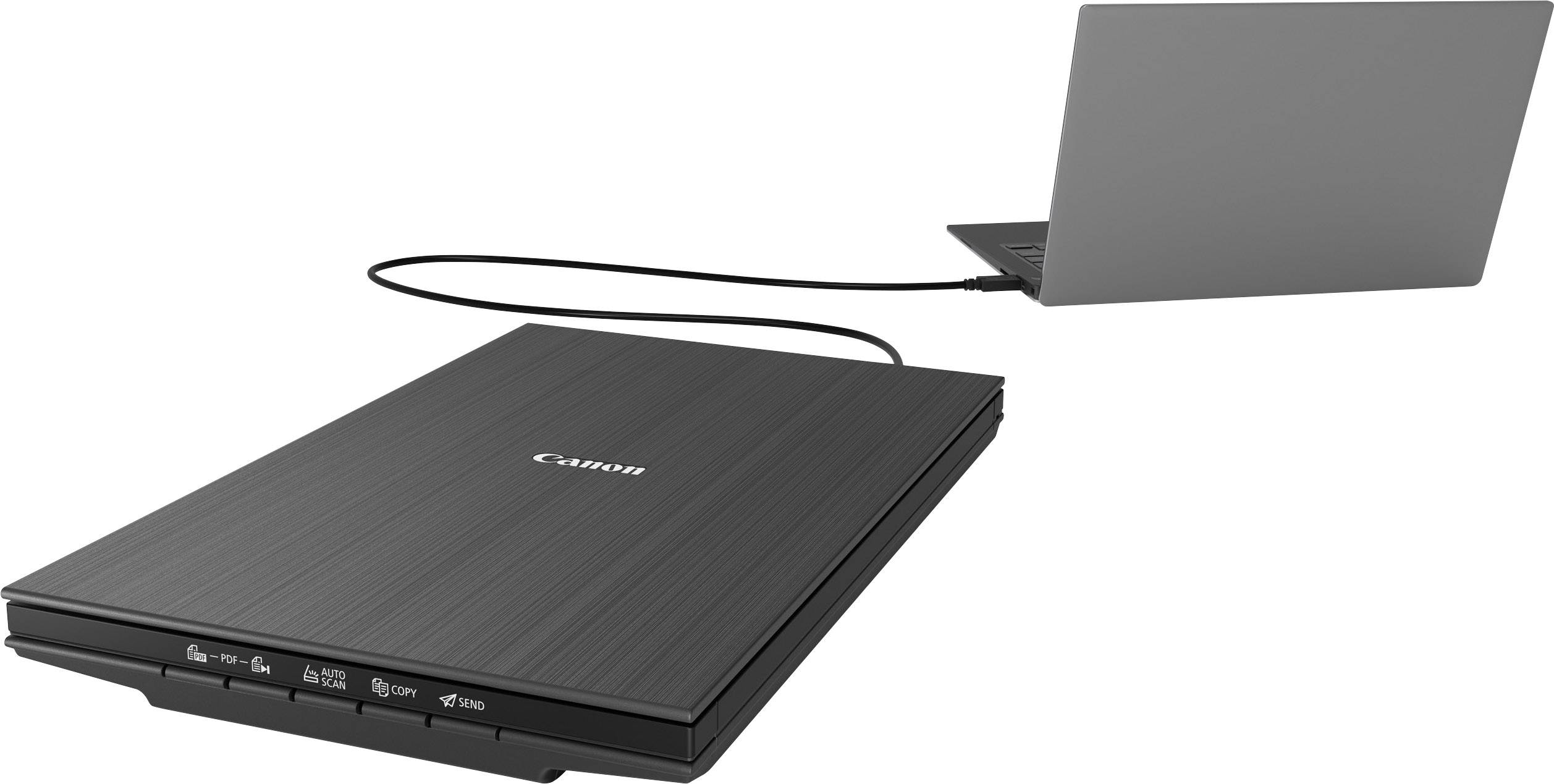 Plochý skener je připojen kabelem k laptopu. Skener je připraven digitalizovat dokumenty nebo obrázky.
