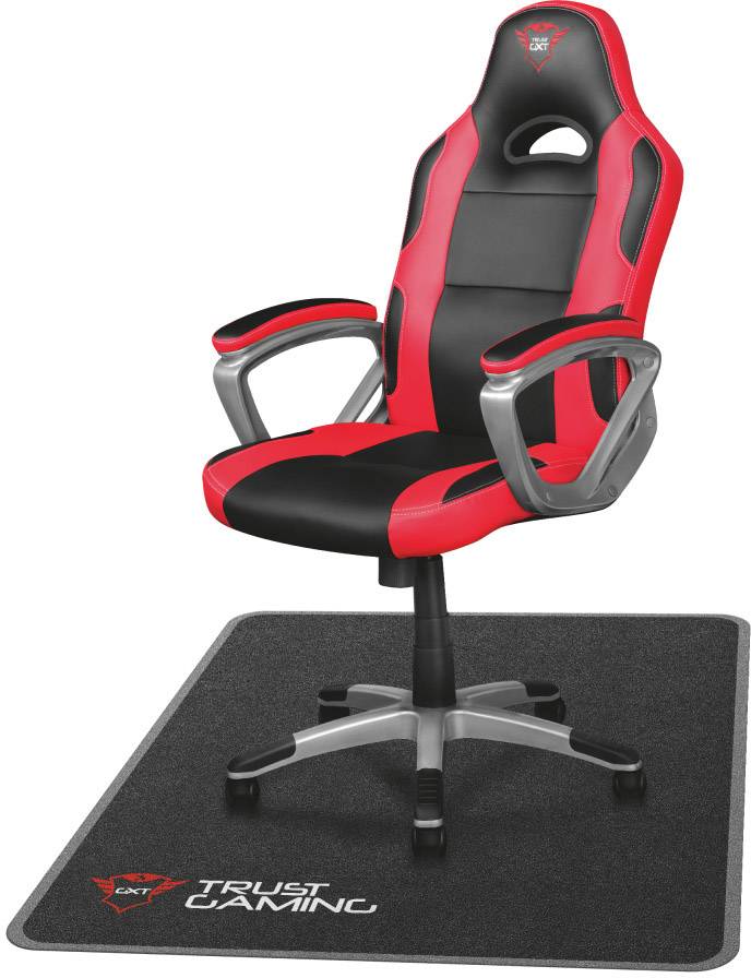 Herní židle v černé a červené barvě s opěrkami rukou umístěná na černém koberci s logem 'Trust Gaming'.
