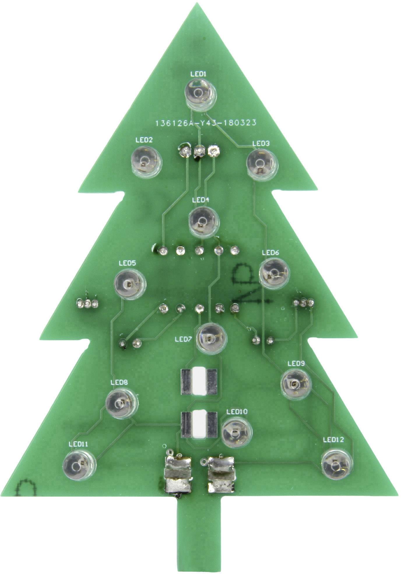 Zelená deska plošných spojů ve tvaru vánočního stromku s LED diodami a elektronickými komponenty, pravděpodobně určená pro dekorativní nebo vzdělávací účely.