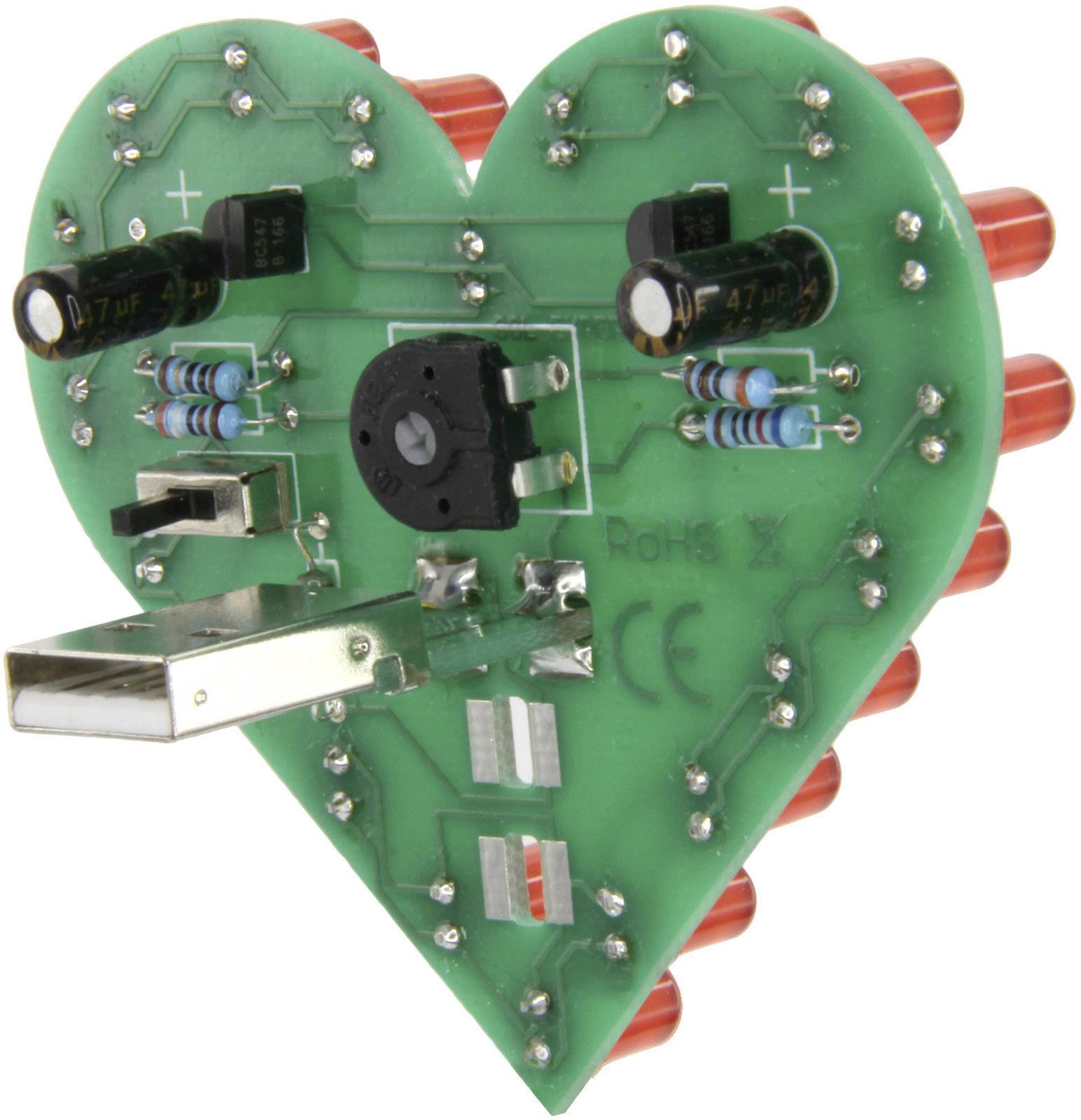 Srdcovitá zelená deska plošných spojů s elektronickými komponenty, červenými LED diodami a USB portem, která ukazuje technickou kreativitu.