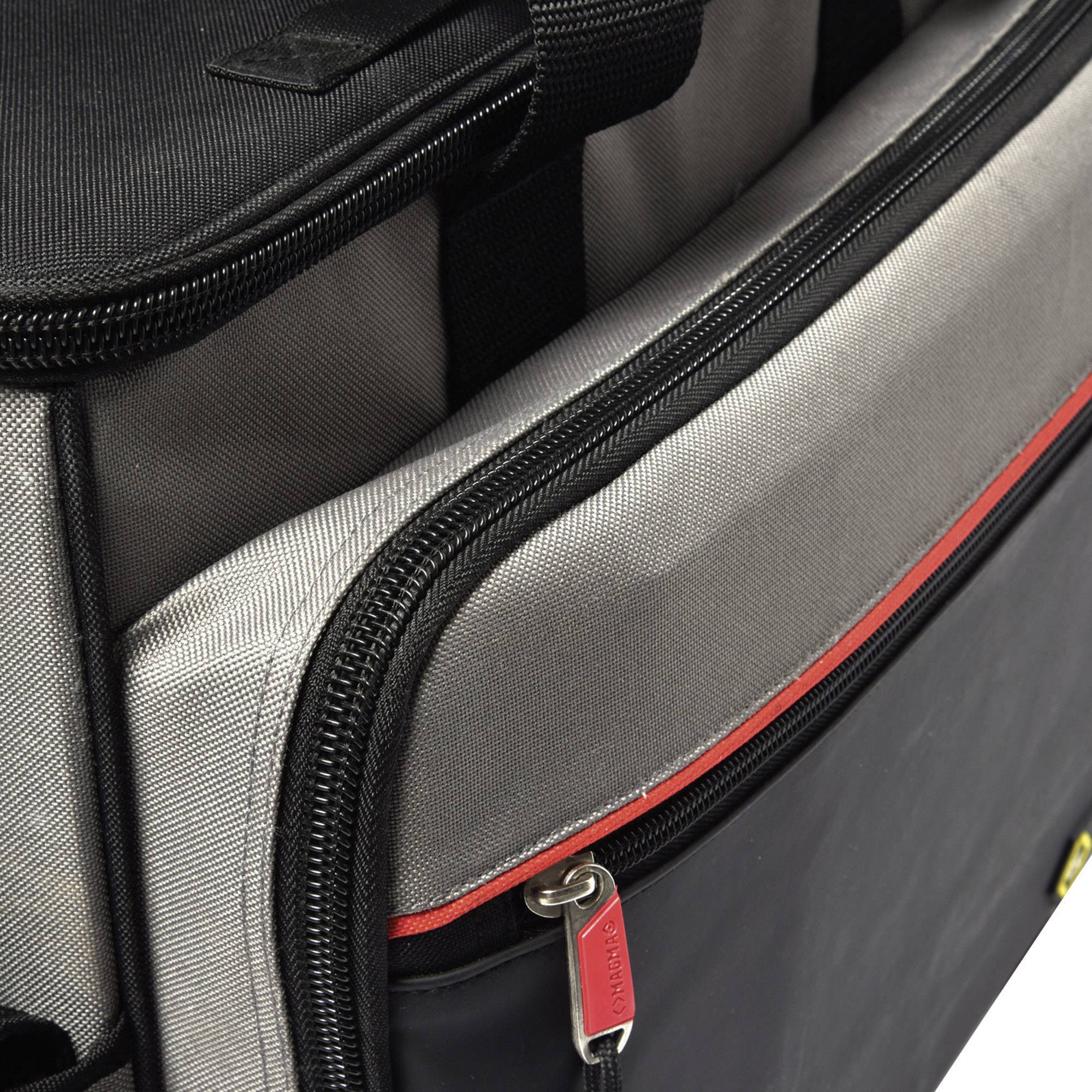 Otevřený černý kufr s šedou vnitřní podšívkou. Je vidět červený zip.