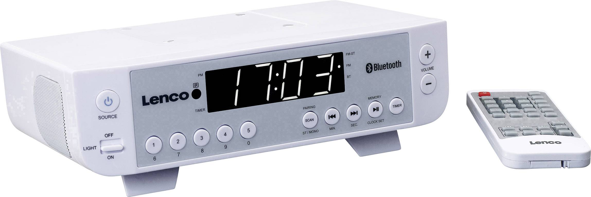 Bílé digitální hodiny s funkcí Bluetooth zobrazují čas '17:10:23', vedle nich leží dálkový ovladač.