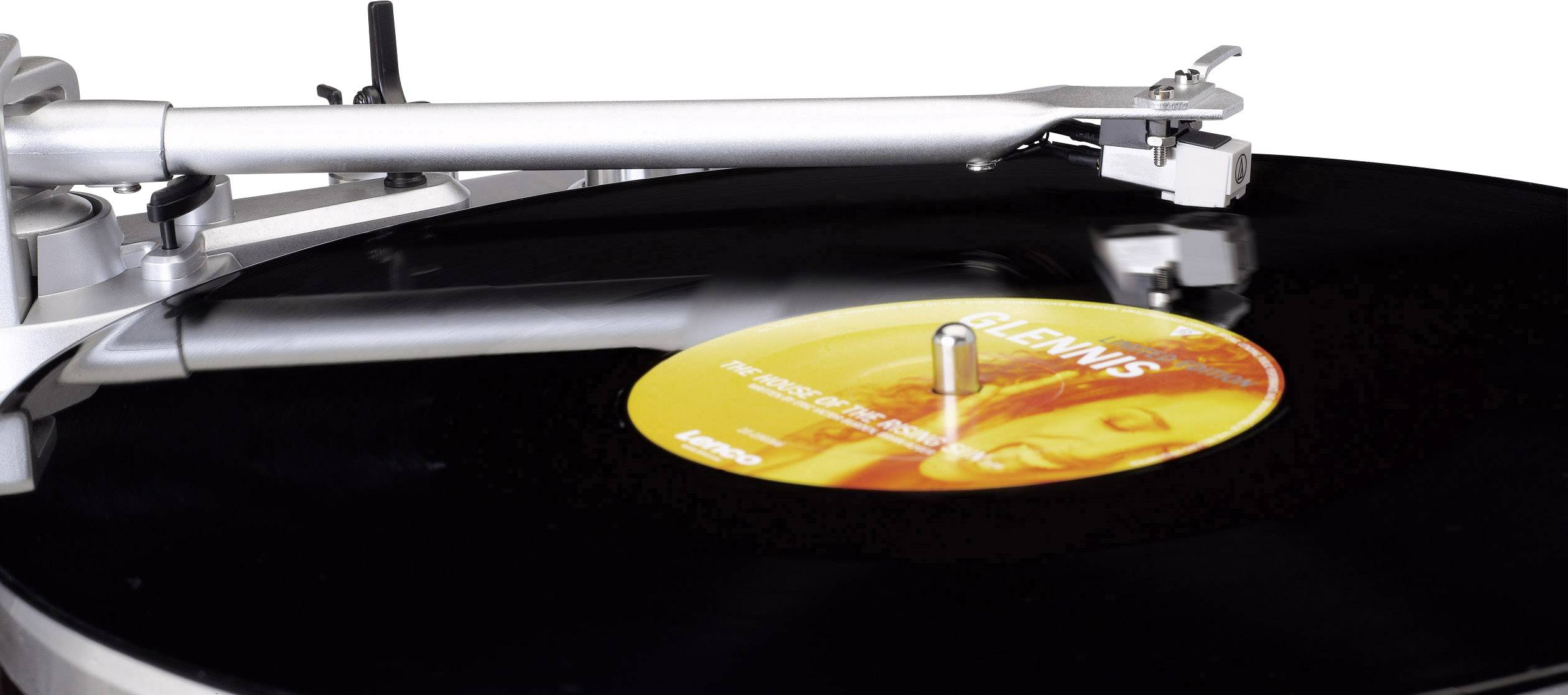 Gramofon přehrává černou vinylovou desku s oranžovým štítkem. Rameno je spuštěné a deska se otáčí.