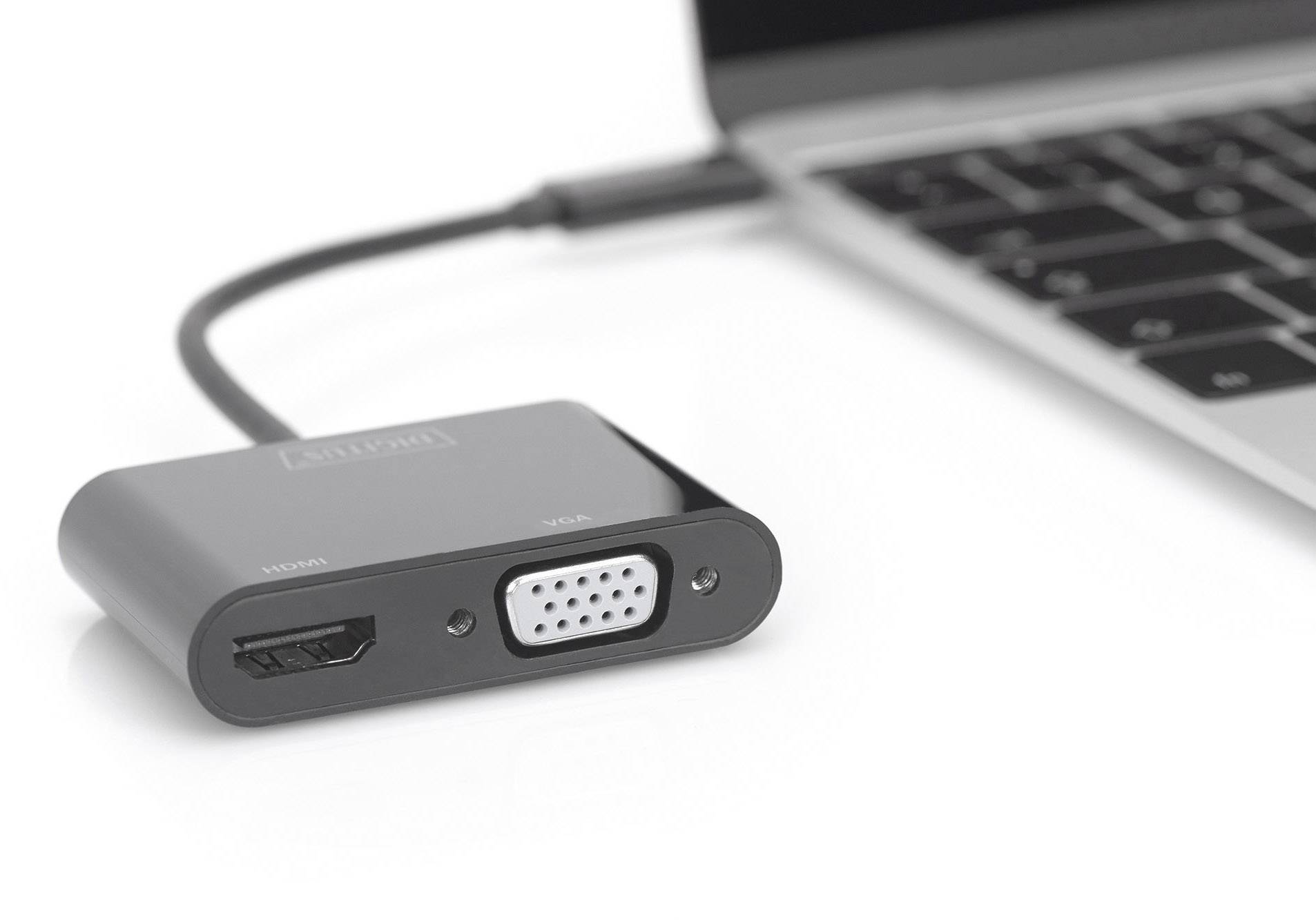 Černý USB adaptér s HDMI a VGA porty je připojen k laptopu.