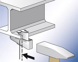 Diagram znázorňuje upevnění matice na ocelovém nosníku pomocí klínu pro zajištění. Šipka ukazuje směr zasunutí klínu.