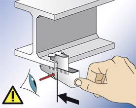 Jedna ruka používá měřicí nástroj ke změření vzdálenosti kovového profilu. Bezpečnostní upozornění: Používejte ochranné brýle.