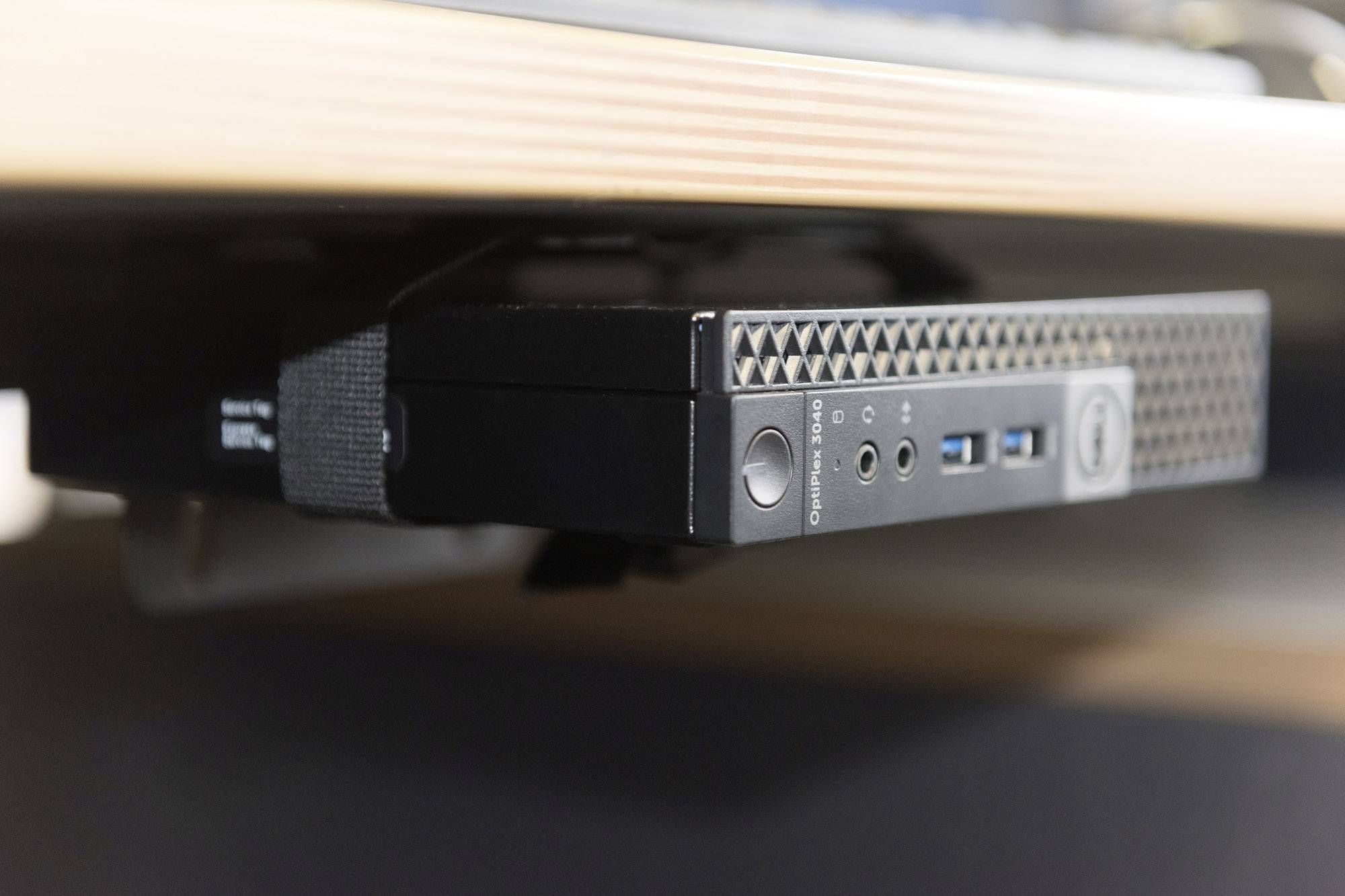 Kompaktní počítač je namontován pod stolem. Disponuje různými porty, včetně USB vstupů.