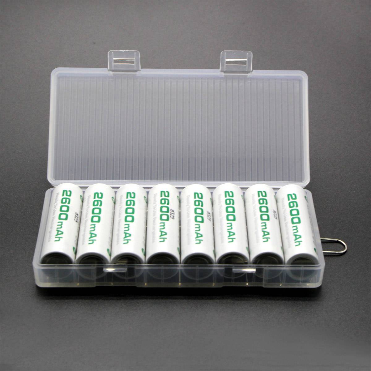 Osm bílých AA baterií s kapacitou 2600 mAh, označených na každé baterii, uspořádaných v průhledné plastové krabičce na šedém pozadí.