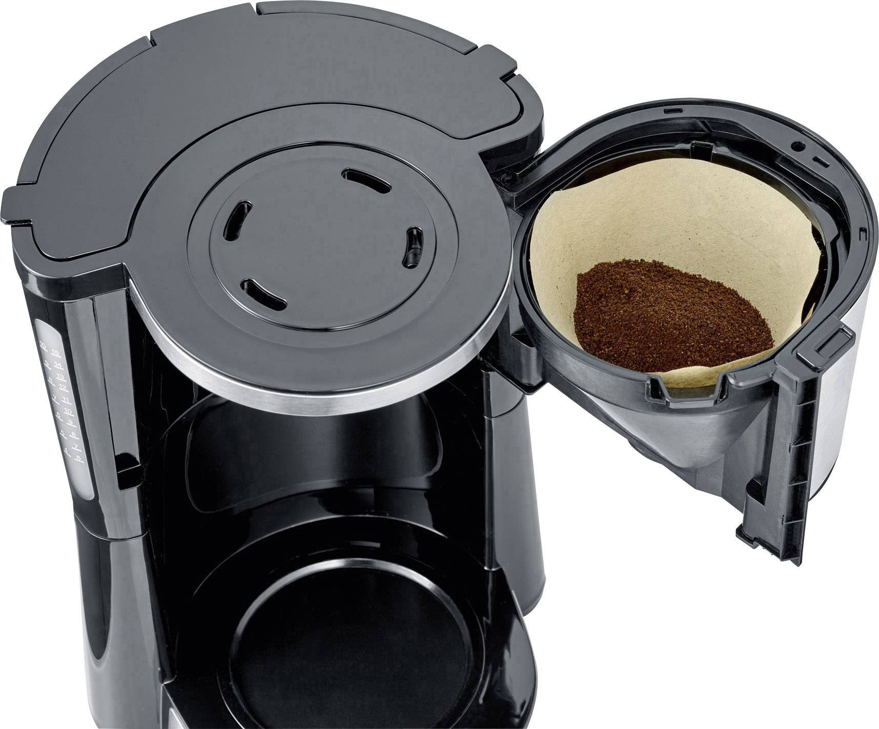 Kávový přístroj s otevřeným držákem filtru, naplněný kávovou moučkou, připravený k přípravě.