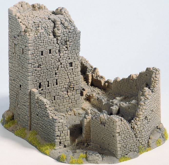 Miniaturní model staré hradní zříceniny s texturovanými kamennými zdmi a částečně zříceným opevněním na zelené základně.