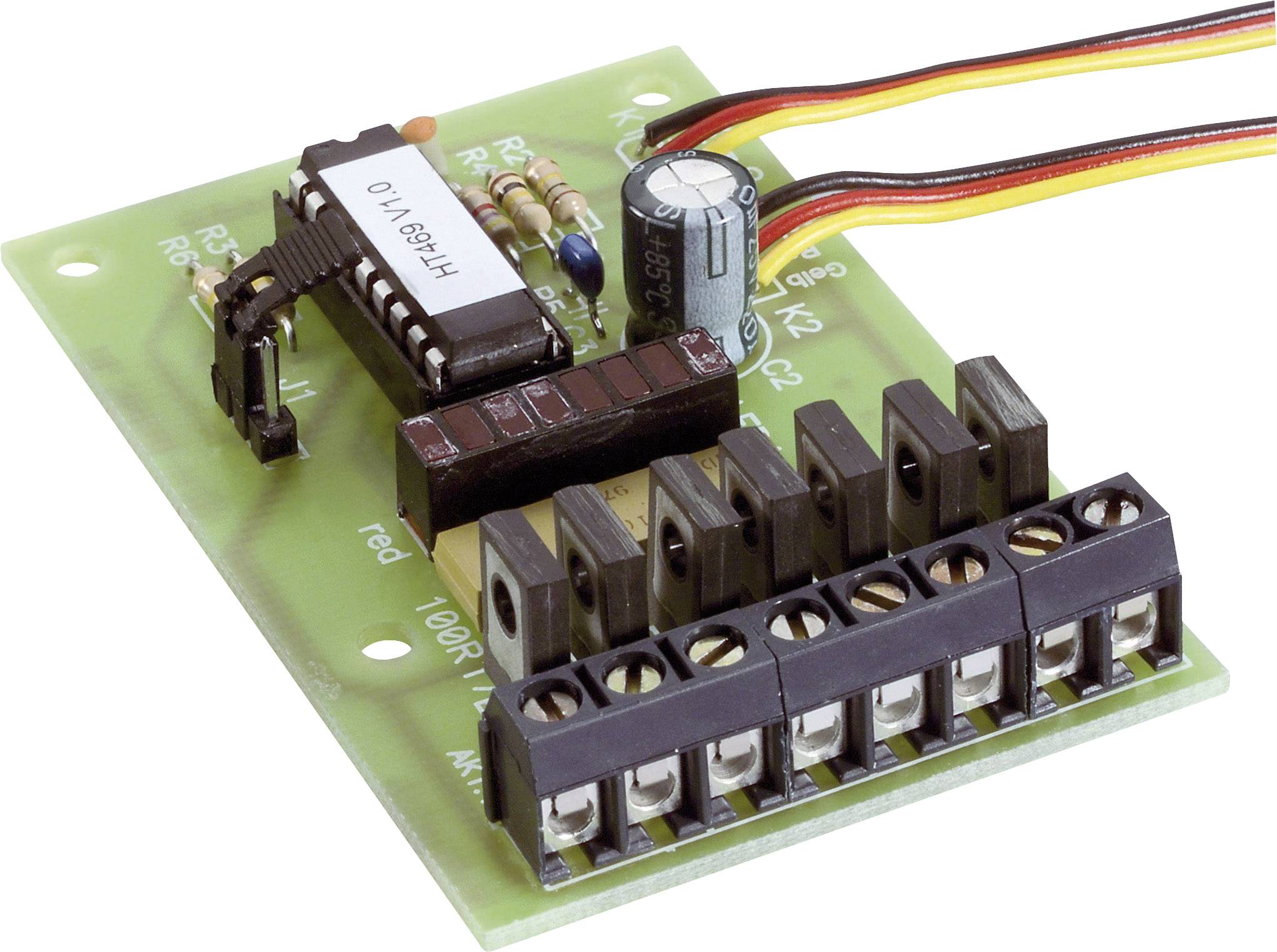 Zelená deska plošných spojů s několika elektronickými komponenty, jako jsou rezistory, kondenzátor a integrovaný obvod.
