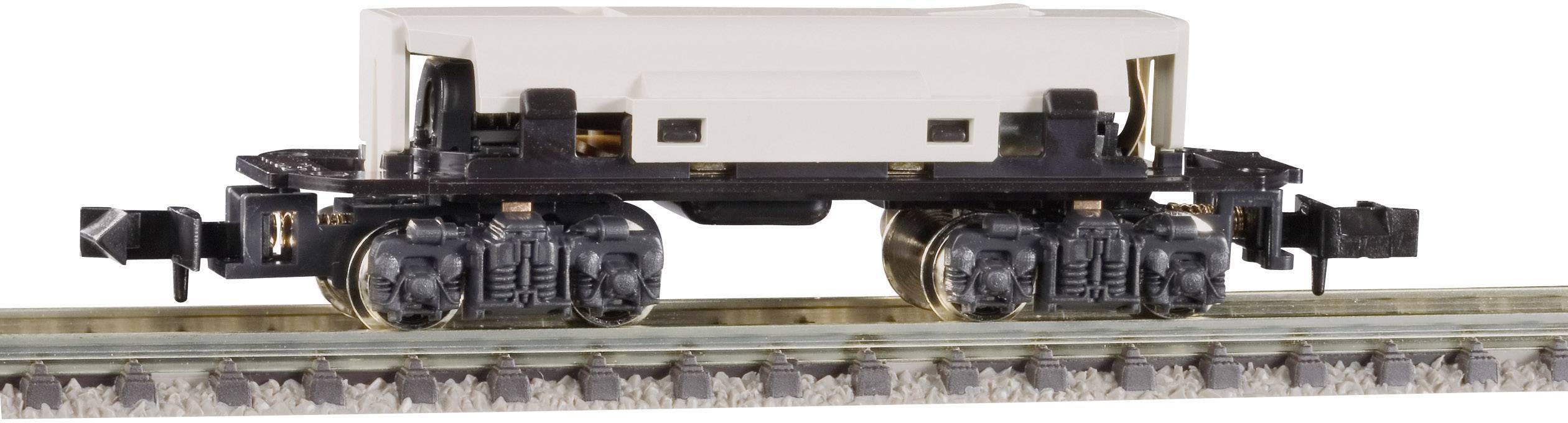 Model železničního vozu bez karoserie umístěný na kolejích, s viditelnými koly a podvozkem.