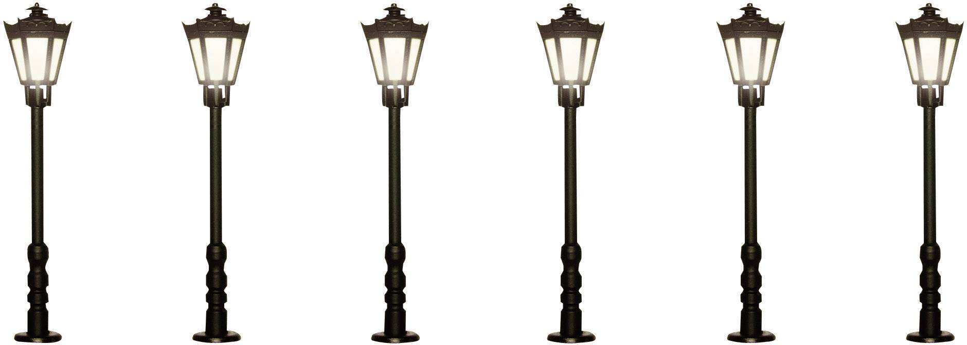Šest identických historických pouličních lamp s osvětlenými žárovkami seřazených v řadě.